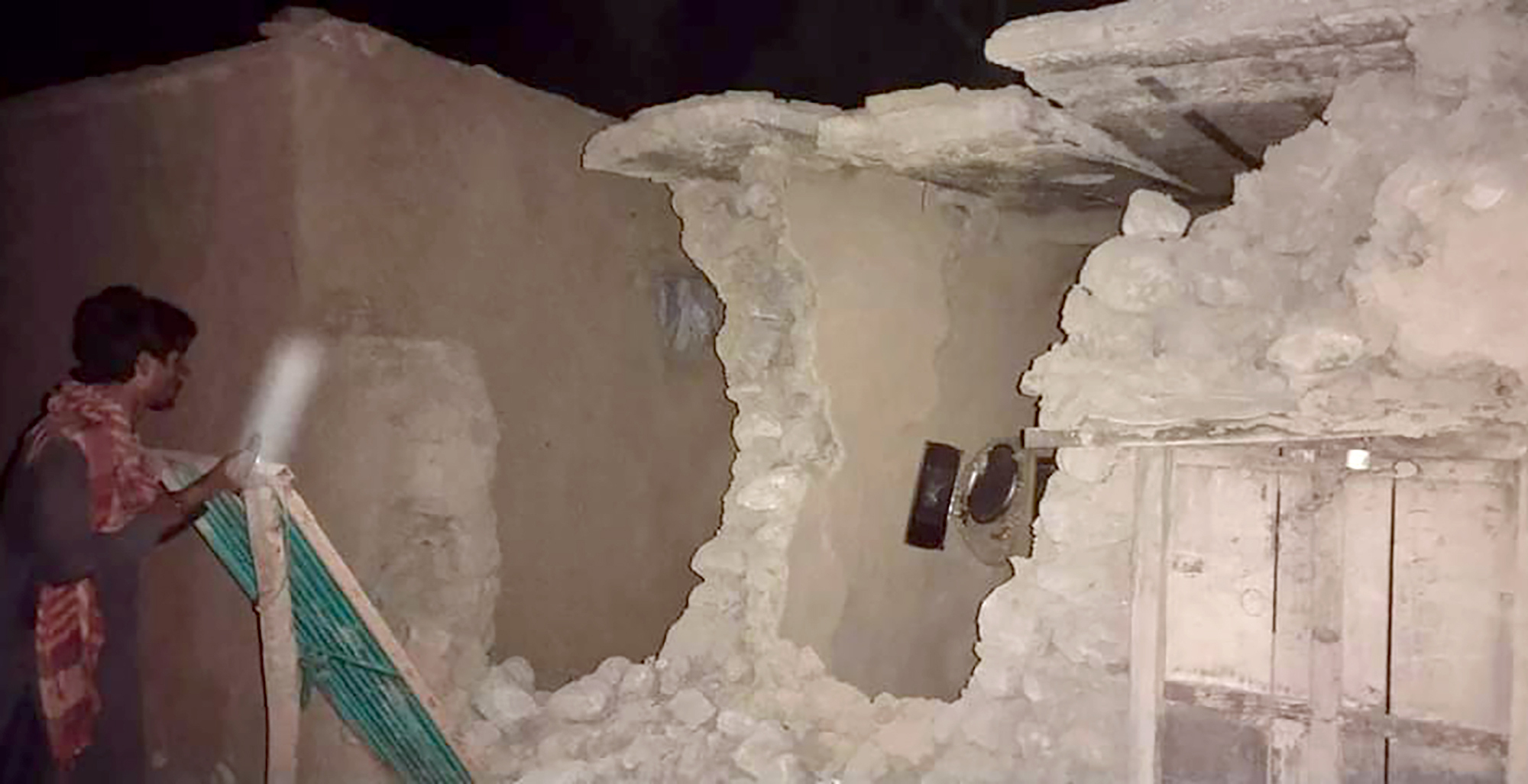 A local resident looks his damaged house following a severe earthquake hit the area, in Harnai, about 60 miles from Quetta, Pakistan, on Oct. 7, 2021. (Associated Press)