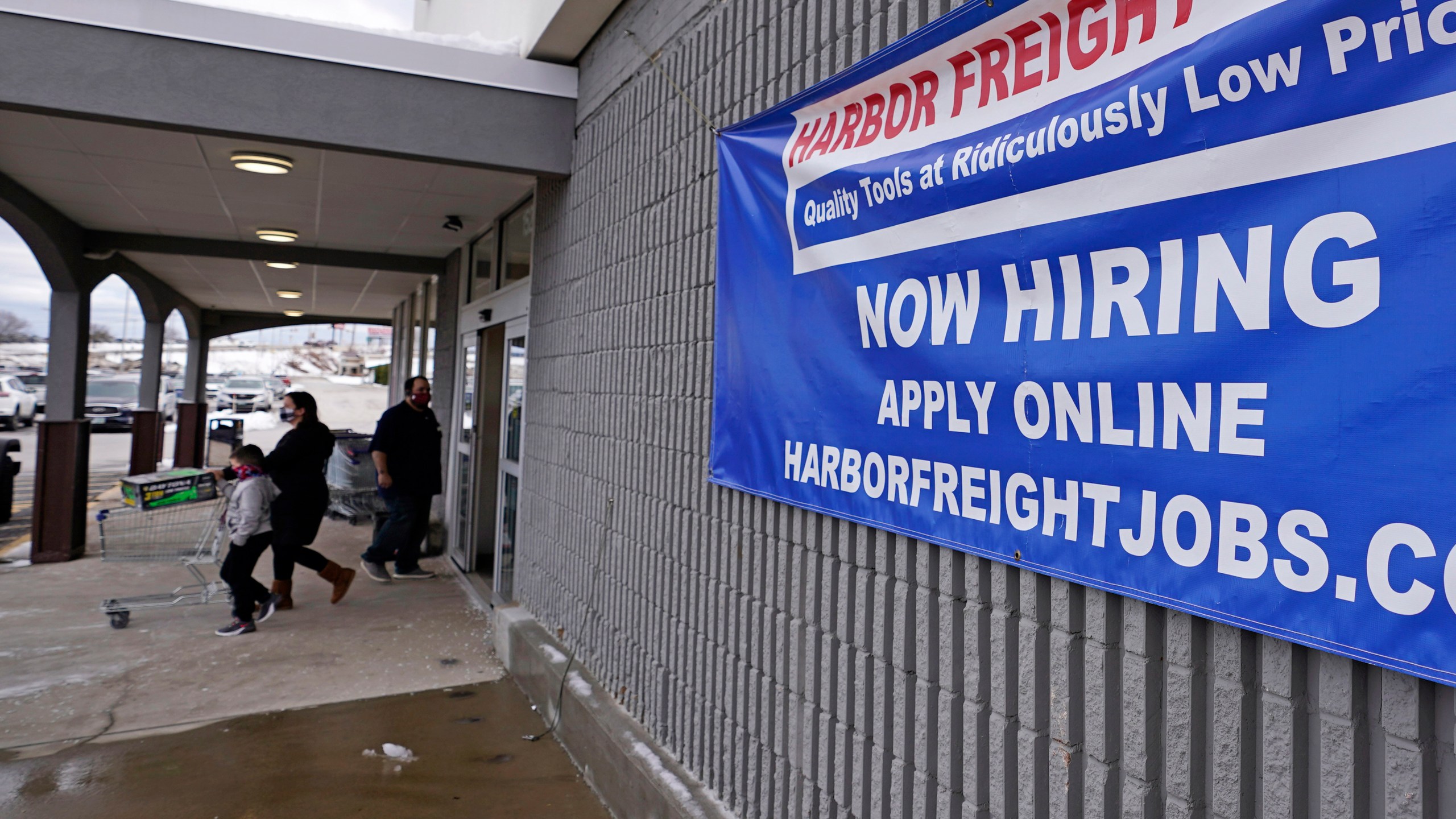 In this Dec. 10, 2020, file photo, a "Now Hiring" sign hangs on the front wall of a Harbor Freight Tools store in Manchester, N.H. When the U.S. government issues the September jobs report on Friday, Oct. 8, 2021, the spotlight will fall not only on how many people were hired last month. A second question will command attention, too: Are more people finally starting to look for work? (AP Photo/Charles Krupa, File)