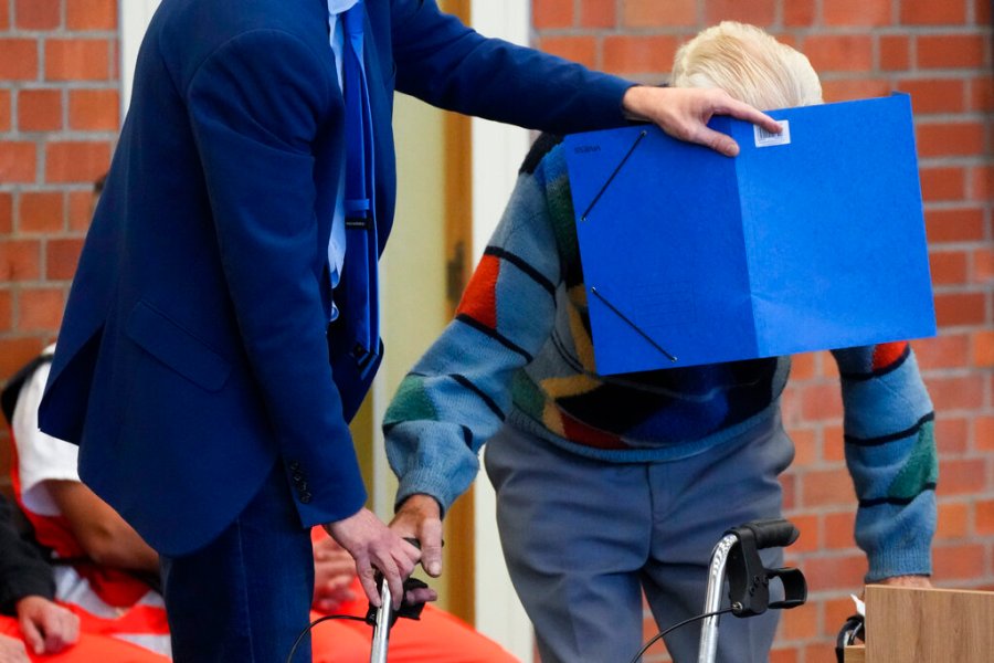 In this Thursday, Oct. 7, 2021 file photo, lawyer Stefan Waterkamp covers the face of accused Josef S. as they arrive at a courtroom in Brandenburg, Germany. (AP Photo/Markus Schreiber, File)