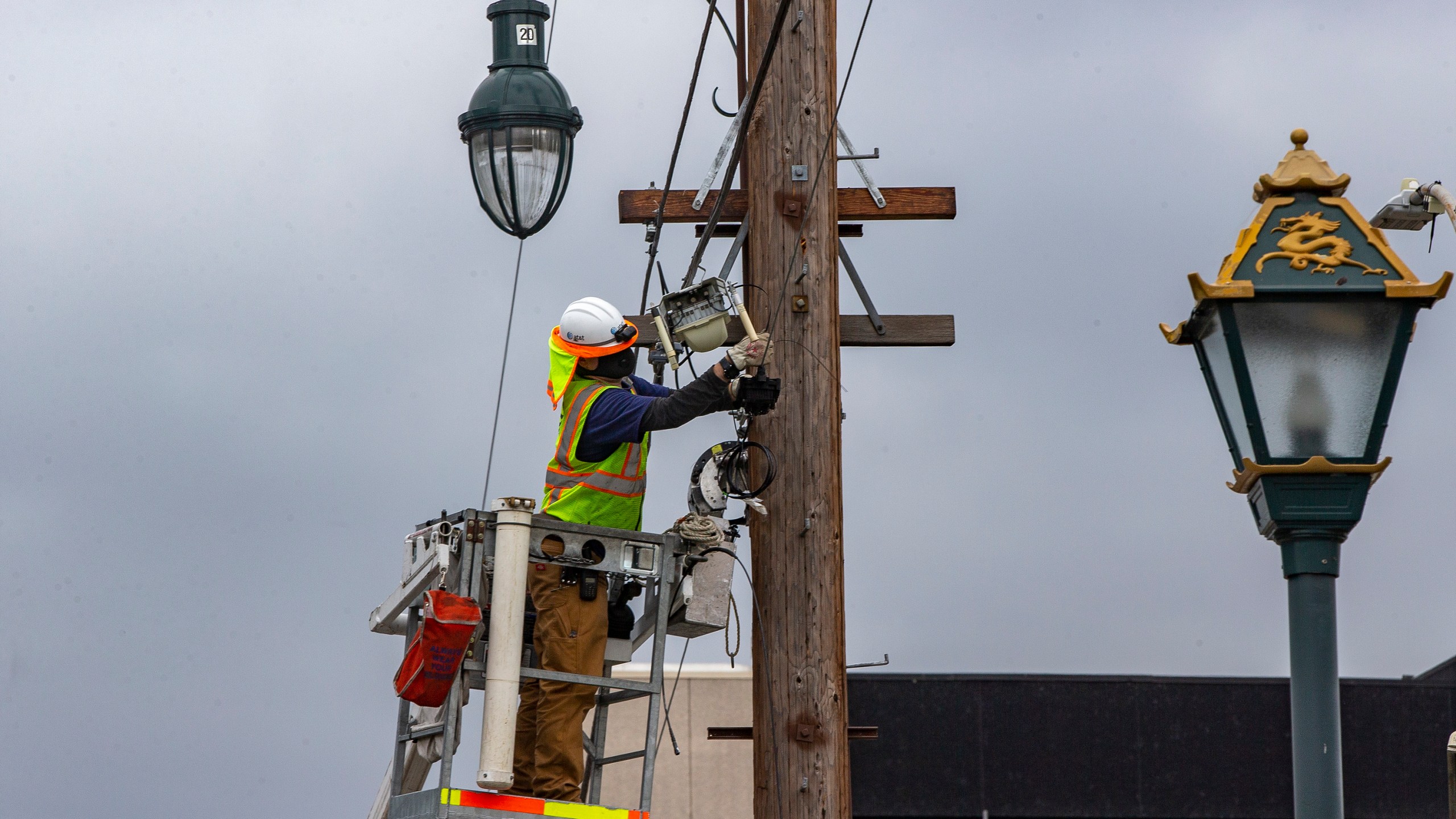 AT&T workers deploy fiber optic lines for a cellphone tower station in the Chinatown neighborhood of Los Angeles on June 5, 2020. (Damian Dovarganes / Associated Press)