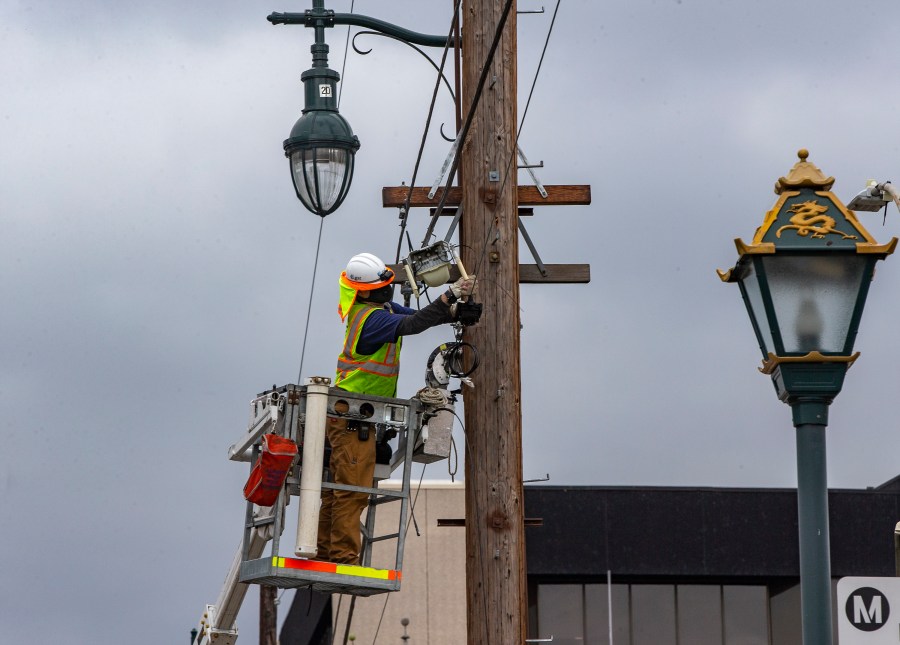 AT&T workers deploy fiber optic lines for a cellphone tower station in the Chinatown neighborhood of Los Angeles on June 5, 2020. (Damian Dovarganes / Associated Press)