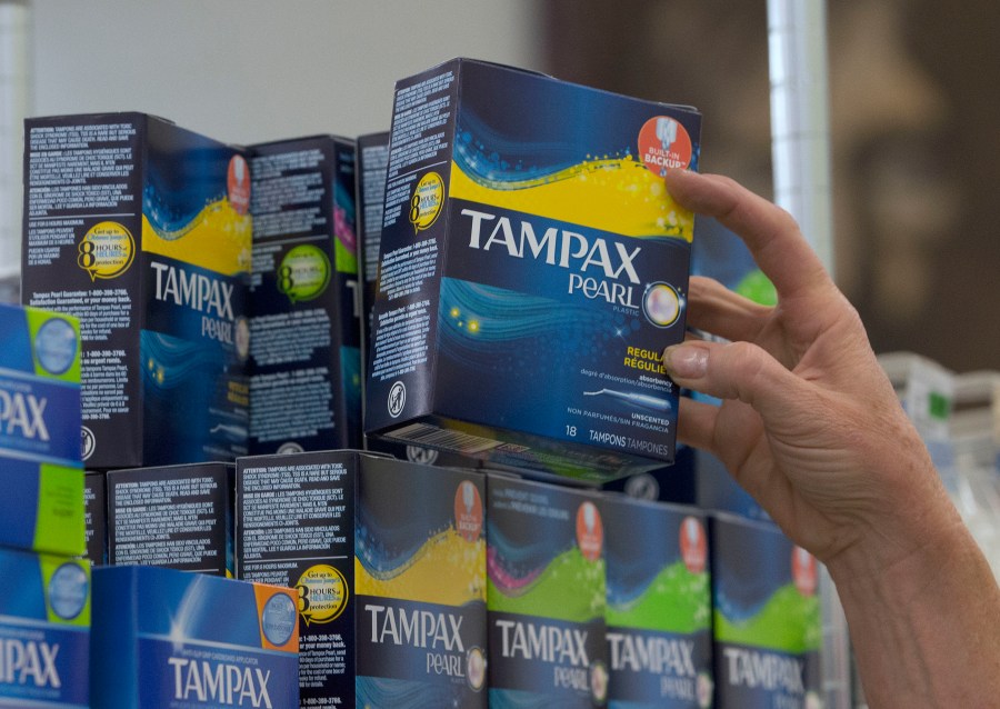 In this June 22, 2016 file photo, Tammy Compton restocks tampons at Compton's Market, in Sacramento, Calif. California public schools and colleges must stock their restrooms with free menstrual products under a new law signed by Gov. Gavin Newsom, Friday, Oct. 8, 2021. (AP Photo/Rich Pedroncelli, File)