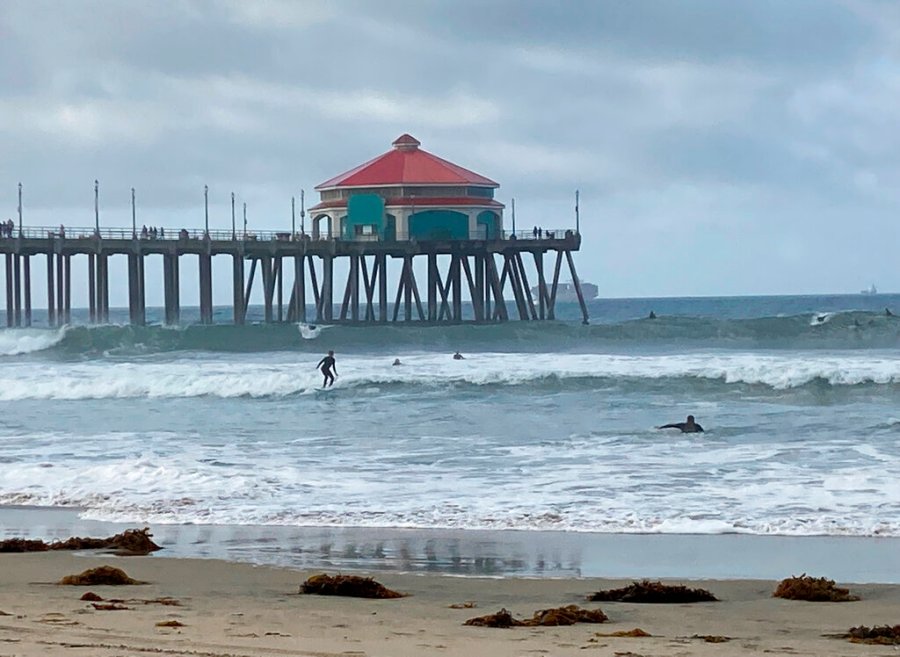 Surfers and swimmers return to the Huntington Beach pier waves since the crude oil spill at the California beach, Monday, Oct. 11, 2021. (AP Photo/Amy Taxin)