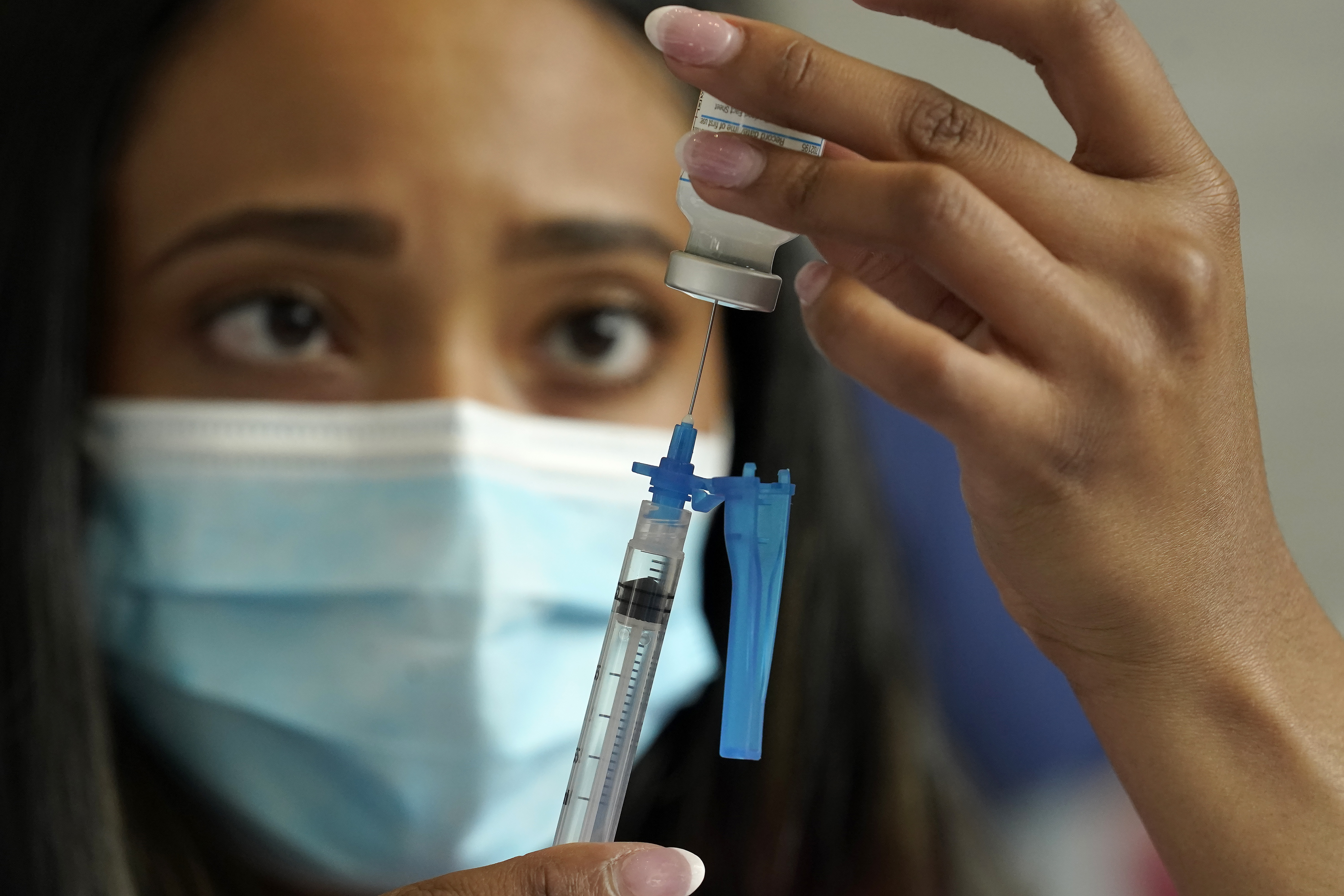 In this May 19, 2021, file photo, a licensed practical nurse draws a Moderna COVID-19 vaccine into a syringe at a mass vaccination clinic at Gillette Stadium in Foxborough, Mass. Starting Thursday, Oct. 14, 2021, the Food and Drug Administration convenes its independent advisers for the first stage in the process of deciding whether extra shots of Moderna or Johnson & Johnson vaccines should be dispensed and, if so, who should get them and when. (AP Photo/Steven Senne, File)