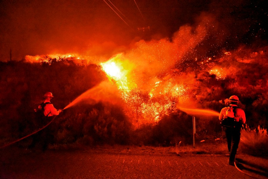 A pair of firefighting dozers, left, cut a line along the western flank of the Alisal Fire near Tajiguas Beach in Santa Barbara County on Oct 12, 2021. (Mike Eliason / Santa Barbara County Fire via Associated Press)