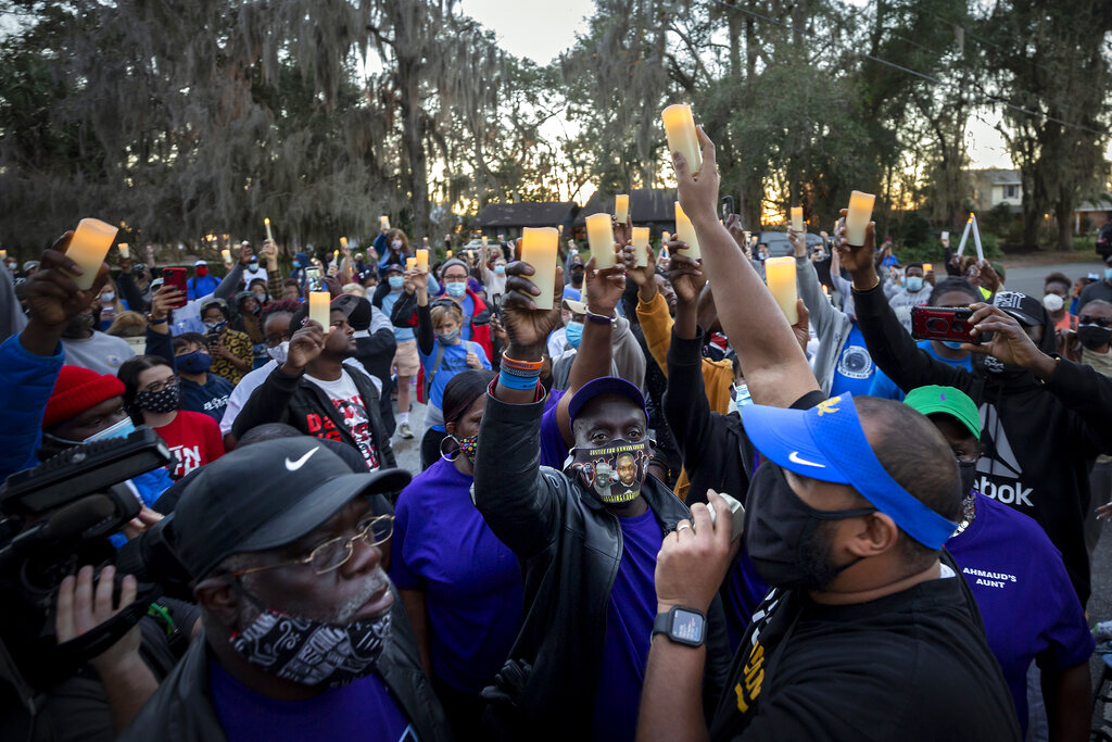 In this Feb. 23, 2021, file photo, Ahmaud Arbery's father, Marcus Arbery, bottom center, listens to Jason Vaughn speak during a memorial walk and candlelight vigil for Ahmaud at the Satilla Shores development in Brunswick, Ga. (AP Photo/Stephen B. Morton, File)