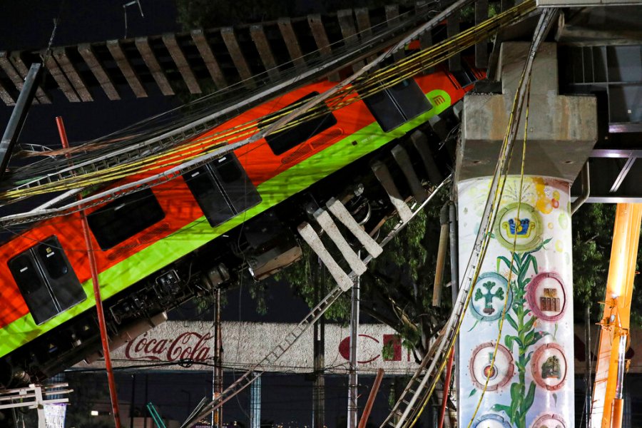 In this May 4, 2021 file photo, Mexico City's subway cars lay at an angle after a section of Line 12 of the subway collapsed in Mexico City. Mexico City´s prosecutor´s office concluded Thursday, Oct. 14, 2021, that the accident was due to mistakes made during the construction of the metro line and that it will prosecute those involved in the crash. (AP Photo/Marco Ugarte, File)