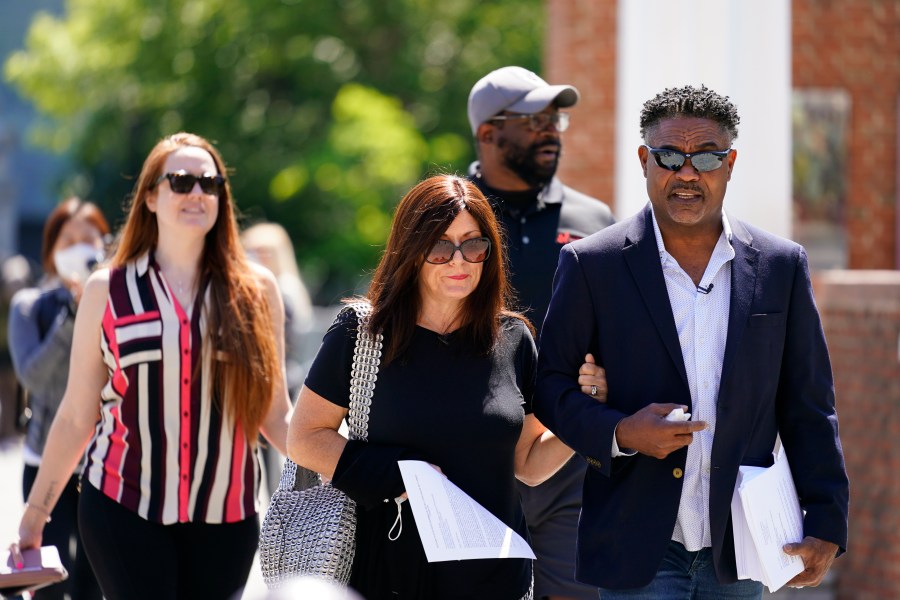 In this May 14, 2021, file photo, former NFL players Ken Jenkins, right, and Clarence Vaughn III, center right, along with their wives, Amy Lewis, center, and Brooke Vaughn, left, carry petitions demanding equal treatment for everyone involved in the settlement of concussion claims against the NFL, to the federal courthouse in Philadelphia on May 14, 2021. (Matt Rourke/Associated Press)