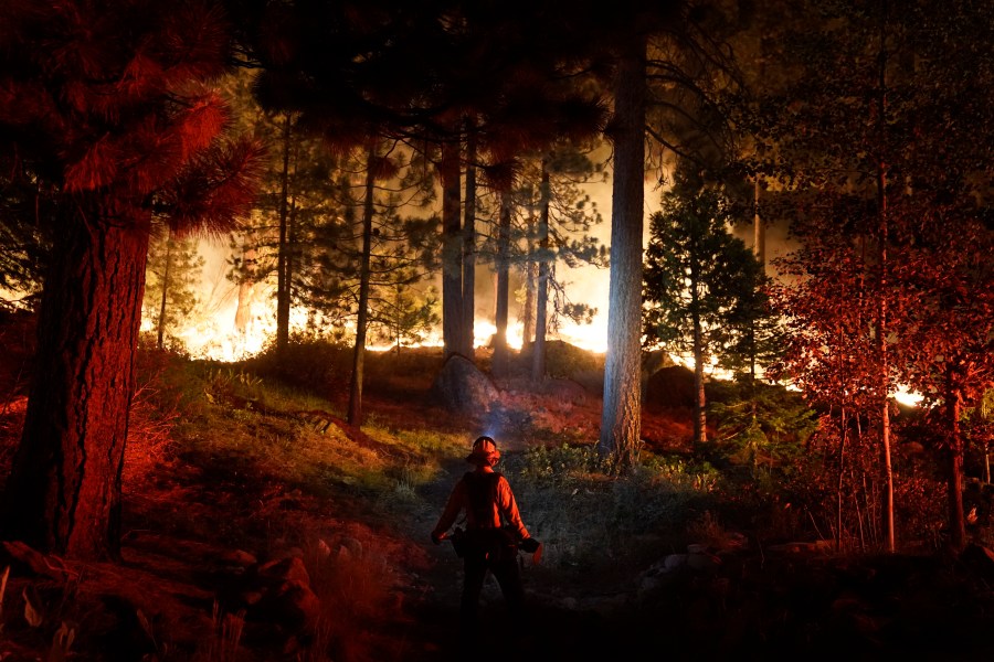 In this Aug. 30, 2021, file photo, a firefighter monitors the Caldor Fire burning near homes in South Lake Tahoe. (Jae C. Hong/Associated Press)