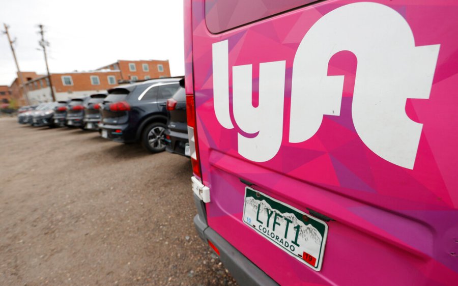 In this April 30, 2020, file photo, Kia Neros that are part of the Lyft ride-hailing fleet sit unused in a lot near Empower Field at Mile High in Denver. Lyft says more than 1,800 sexual assaults were reported by riders in 2019, and the number of incidents has been rising sharply in recent years. (AP Photo/David Zalubowski, File)