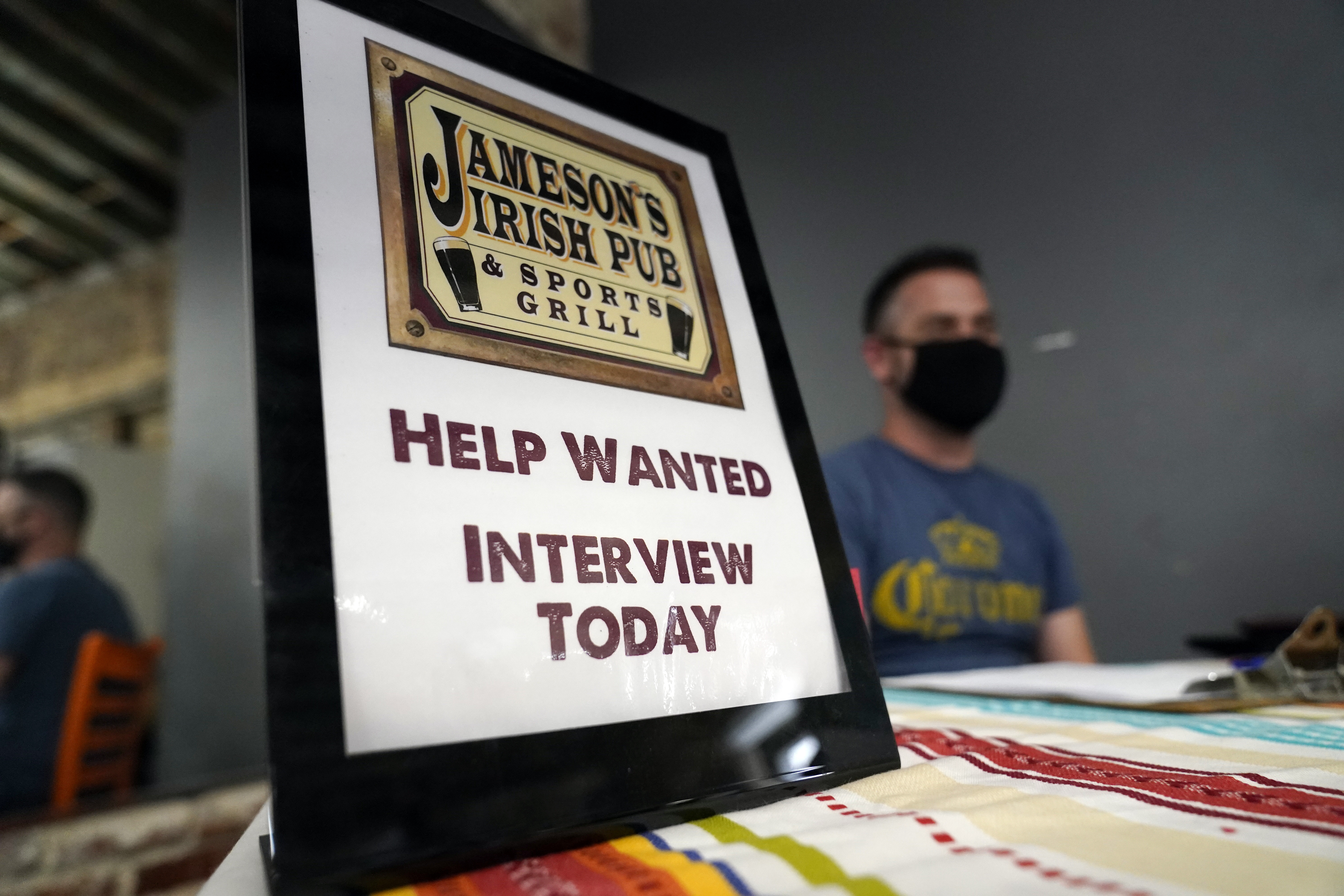 In this Sept. 22, 2021, file photo, a hiring sign is placed at a booth for Jameson's Irish Pub during a job fair in the West Hollywood section of Los Angeles. California's historic hiring slowed down in September as the state added 47,400 new jobs. California has been averaging more than 100,000 new jobs each month since February. New data released Friday, Oct. 22, 2021, by the U.S. Bureau of Labor Statistics shows California is now tied with Nevada for the highest unemployment rate in the country at 7.5%. (AP Photo/Marcio Jose Sanchez, File)