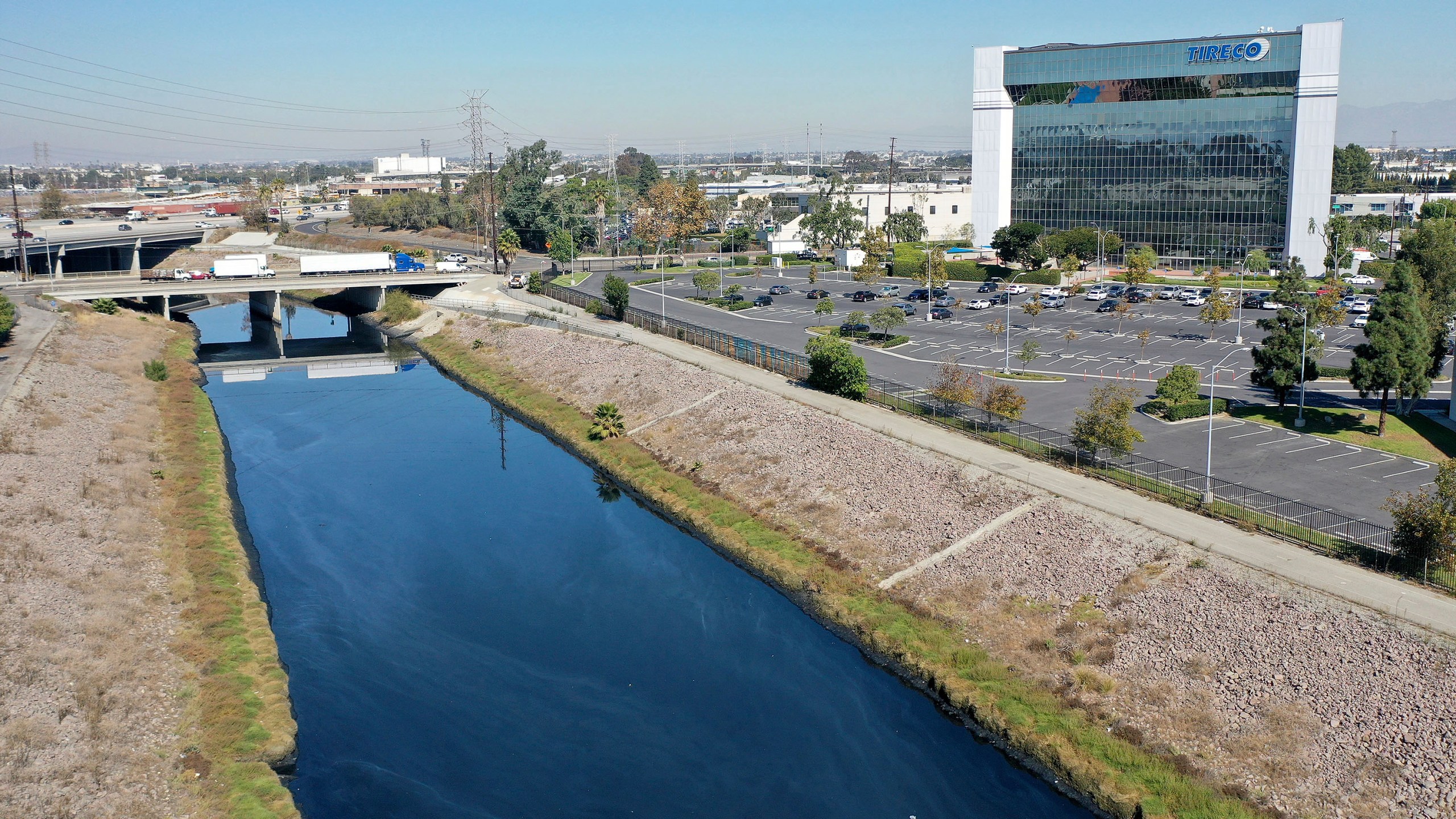 This Thursday, Oct. 21, 21021, aerial image taken with a drone, shows the Dominguez Channel flowing through Carson, Calif. Levels of wretched-smelling hydrogen sulfide gas that have plagued south Los Angeles County communities for weeks are declining as authorities use various mitigation methods in a flood control channel emitting the gross odors, officials said Friday. (Dean Musgrove/The Orange County Register via AP)