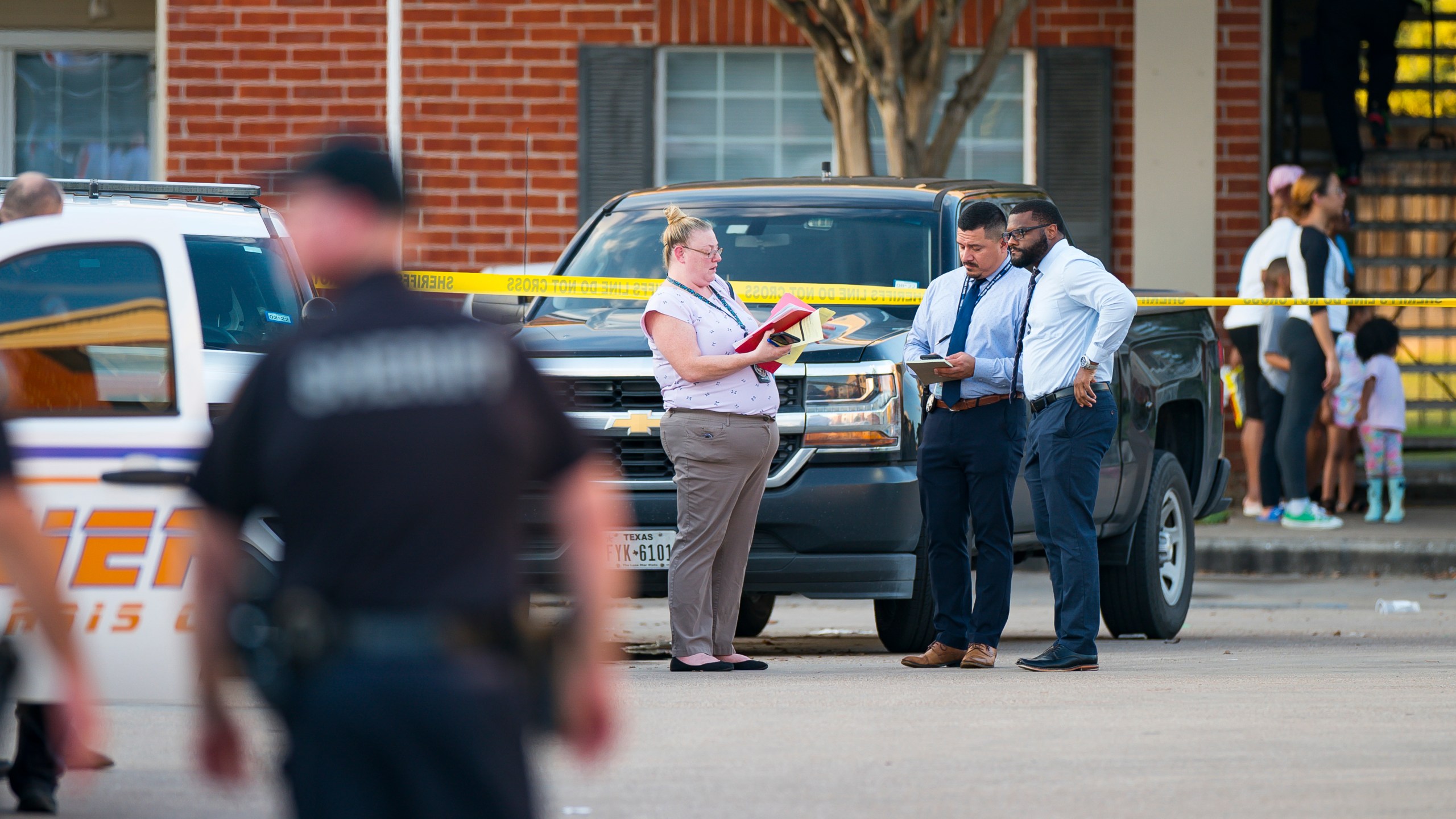 Law enforcement officials investigate a scene where, according to Harris County Sheriff Ed Gonzalez, three juveniles were found living alone along with the skeletal remains of another person, possibly a juvenile, in a third floor apartment at the CityParc II at West Oaks Apartments on Sunday, Oct. 24, 2021, at in west Houston. (Mark Mulligan/Houston Chronicle via AP)