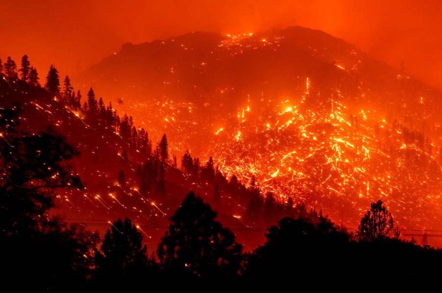 In this Aug. 17, 2021, file photo, embers light up hillsides as the Dixie Fire burns near Milford in Lassen County, Calif. (AP Photo/Noah Berger, File)