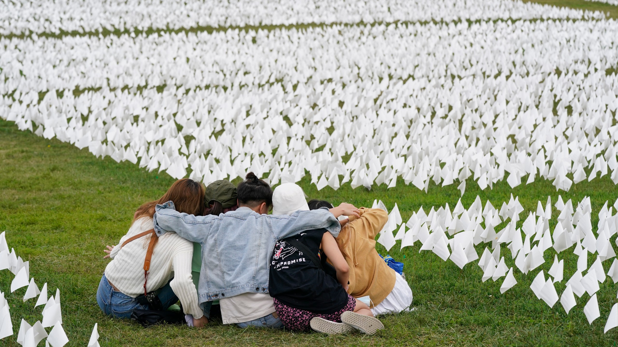 In this Sept. 21, 2021, file photo, visitors sit among white flags that are part of artist Suzanne Brennan Firstenberg's "In America: Remember," a temporary art installation to commemorate Americans who have died of COVID-19, on the National Mall in Washington. (AP Photo/Patrick Semansky, File)