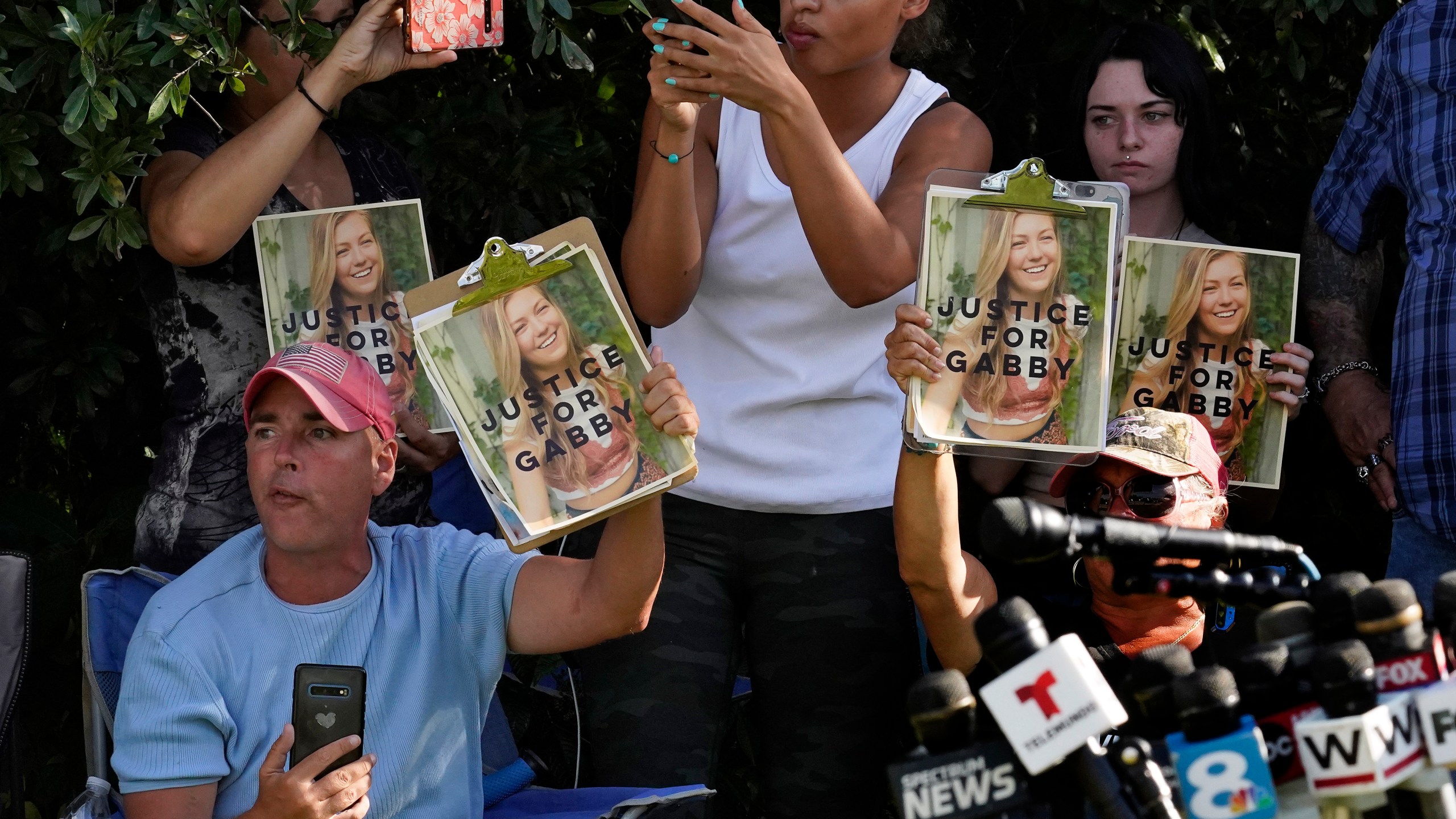 Supporters of Gabby Petito hold up photos of Gabby after a news conference Wednesday, Oct. 20, 2021, in North Port, Fla. Items believed to belong to Brian Laundrie and potential human remains were found in a Florida wilderness park during a search for clues in the slaying of Gabby Petito . (AP Photo/Chris O'Meara)