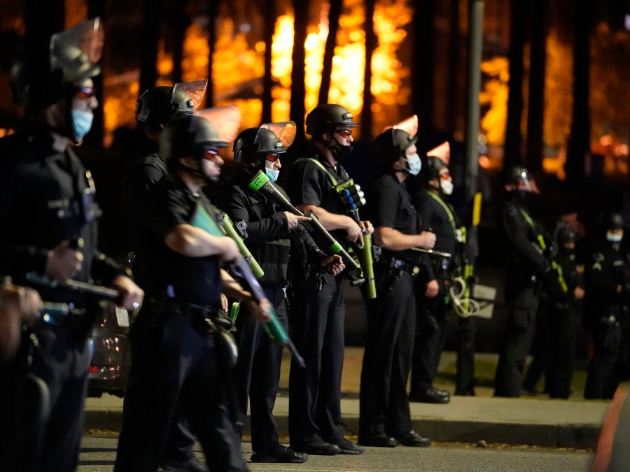 This March 24, 2021, file photo, Los Angeles police officers move in to arrest demonstrators in the Echo Park Lake homeless encampment in Los Angeles. California will project journalists from interference by police while covering civil protests under a bill signed into law Saturday, Oct. 9, by Gov. Gavin Newsom. It was the second new law within days with free speech implications. (AP Photo/Damian Dovarganes)