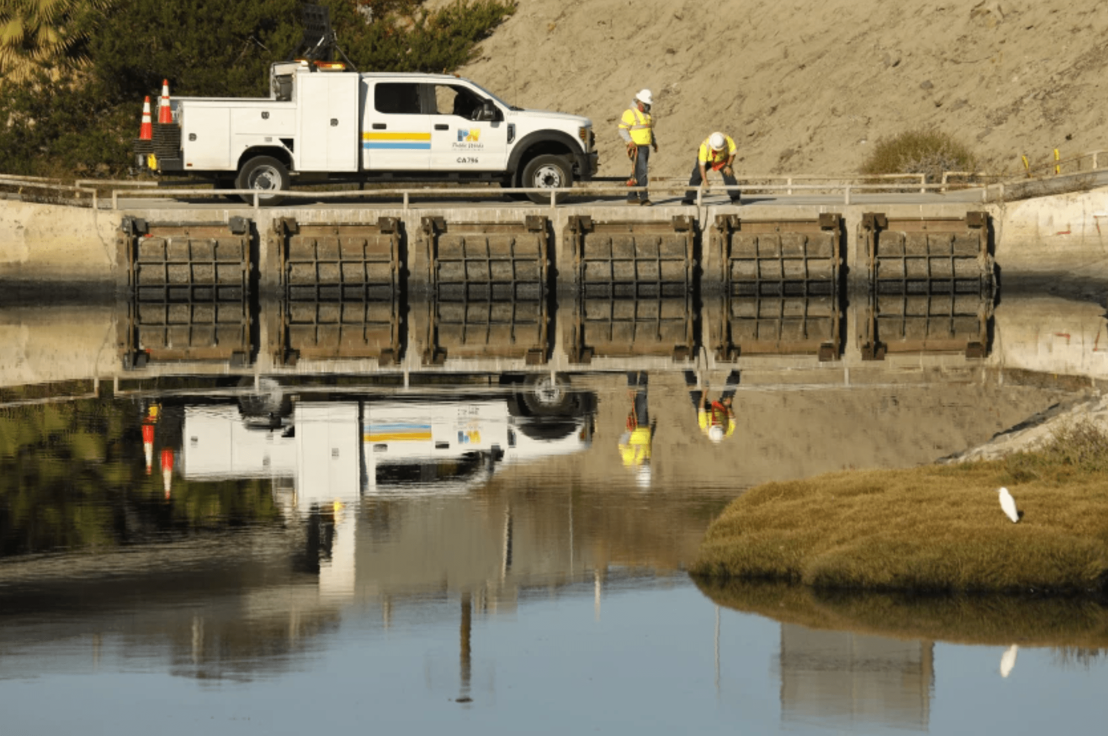 Workers from the Los Angeles County Department of Public Works assess the water quality in the Dominguez Channel in October 2021. (Carolyn Cole / Los Angeles Times)