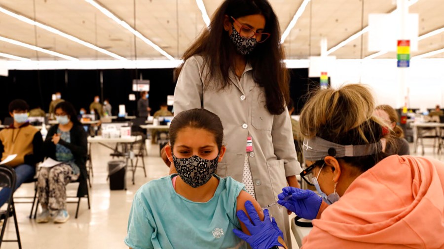 Anaiya Layland, 12, receives her first Pfizer COVID-19 vaccination as her mother, Ashlesha Patel, observes at the Cook County Public Health Department on May 13, 2021, in Des Plaines, Ill. (AP Photo/Shafkat Anowar)