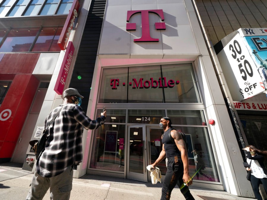 A man uses a mobile phone outside a T-Mobile store, Monday, April 19, 2021, in New York. (AP Photo/Mark Lennihan)