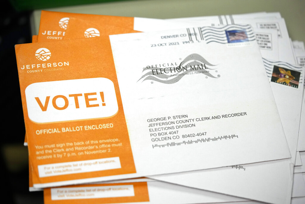 Early ballots wait to be processed by election judges in the Jefferson County, Colo., elections division, Tuesday, Oct. 26, 2021, in Golden, Colo. (AP Photo/David Zalubowski)