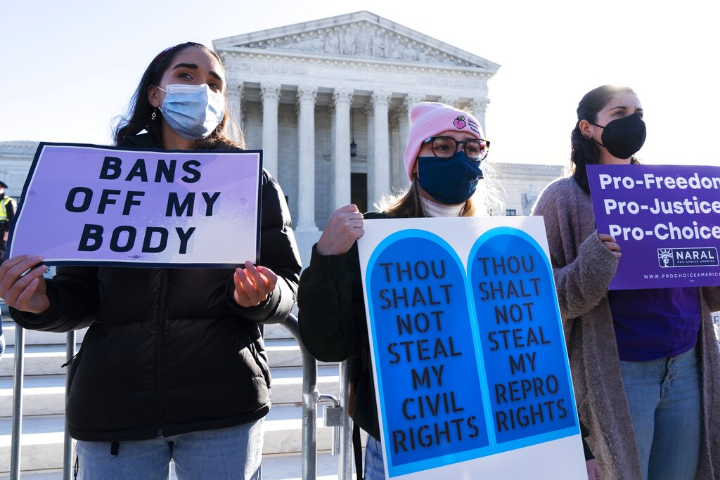 Caroline McDonald, left, a student at Georgetown University, Lauren Morrissey, with Catholics for Choice, and Pamela Huber, of Washington, join a pro-choice rally outside the Supreme Court, Monday, Nov. 1, 2021, as arguments are set to begin about abortion by the court, on Capitol Hill in Washington. (AP Photo/Jacquelyn Martin)