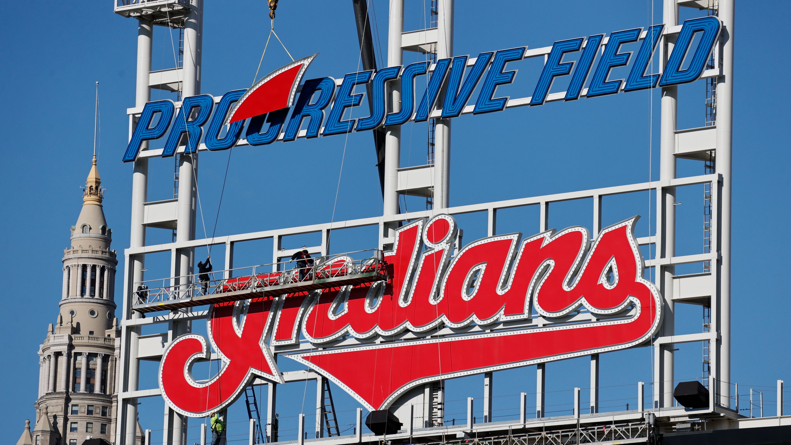 Workers begin to remove the Cleveland Indians sign from above the scoreboard at Progressive Field, on Nov. 2, 2021. (Ron Schwane/Associated Press)