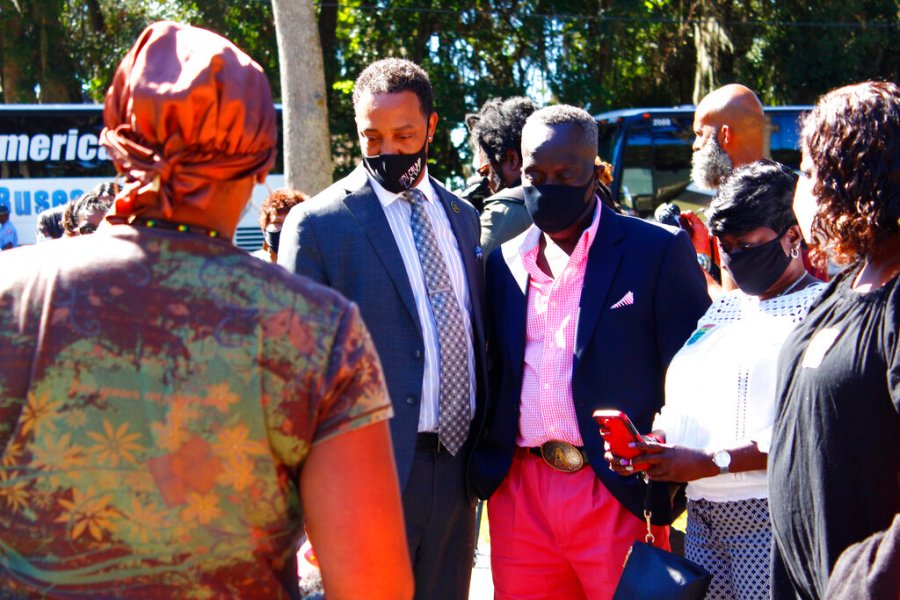 Marcus Arbery stands between a representative of the Transformative Justice Coalition and a community member October 2021 overlooking the stretch of pavement where his son, Ahmaud Arbery, was killed. (Asia Burns/The Atlanta Journal-Constitution via AP)