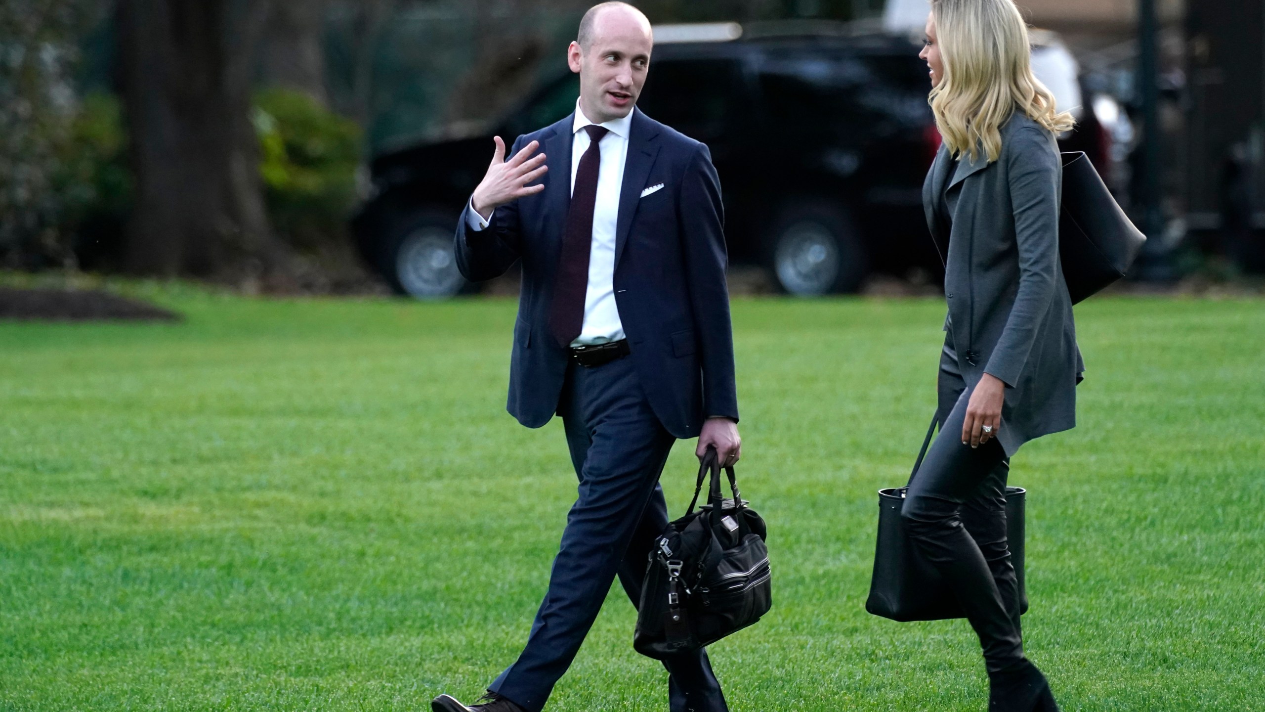 White House press secretary Kayleigh McEnany and White House senior adviser Stephen Miller walk across the South Lawn before boarding Marine One with President Donald Trump at the White House in Washington, on Oct. 20, 2020. (AP Photo/Andrew Harnik, File)