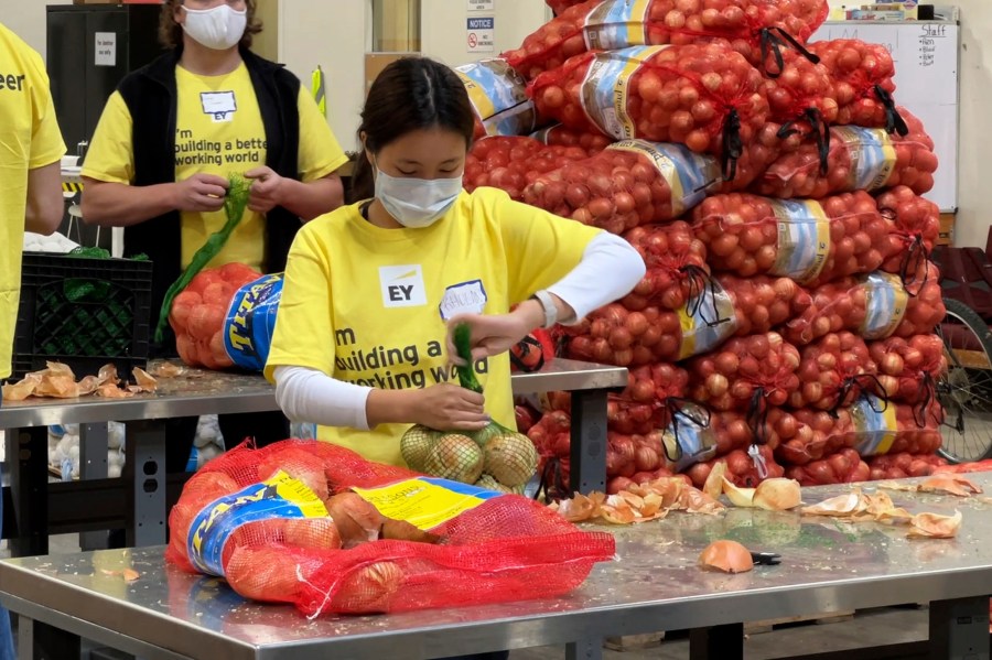 A volunteer packs onions in the warehouse of the Alameda County Community Food Bank in Oakland on Nov. 5, 2021. (AP Photo/Terry Chea)