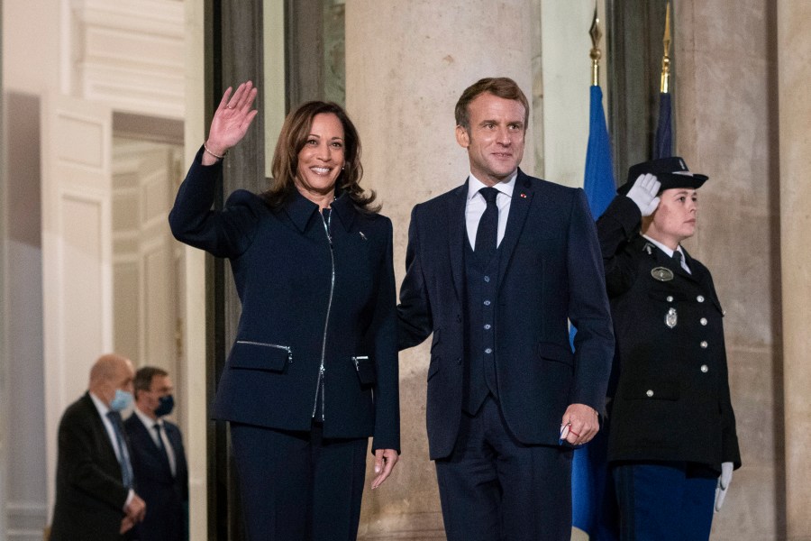 French President Emmanuel Macron stands next to Vice President Kamala Harris as she waves before a bilateral meeting at Élysée Palace in Paris, France on Nov. 10, 2021. (Sarahbeth Maney/The New York Times via AP, Pool)