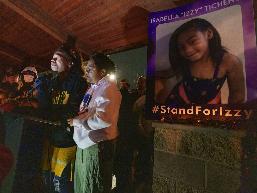 Brittany Tichenor- Cox, center, joined by her sister Jasmine Rhodes, right, speaks about her daughter Izzy Tichenor, as hundreds joined the Tichenor family in mourning the death of 10-year-old Isabella "Izzy" Tichenor during a vigil at Foxboro Hollow Park in North Salt Lake, Utah, on Tuesday, Nov. 9, 2021. (Leah Hogsten/The Salt Lake Tribune via AP)