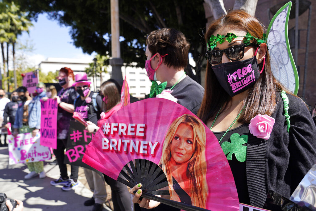 Britney Spears supporter Kiki Norberto holds a hand fan outside a court hearing concerning the pop singer's conservatorship at the Stanley Mosk Courthouse on March 17, 2021, in Los Angeles. (AP Photo/Chris Pizzello, File)