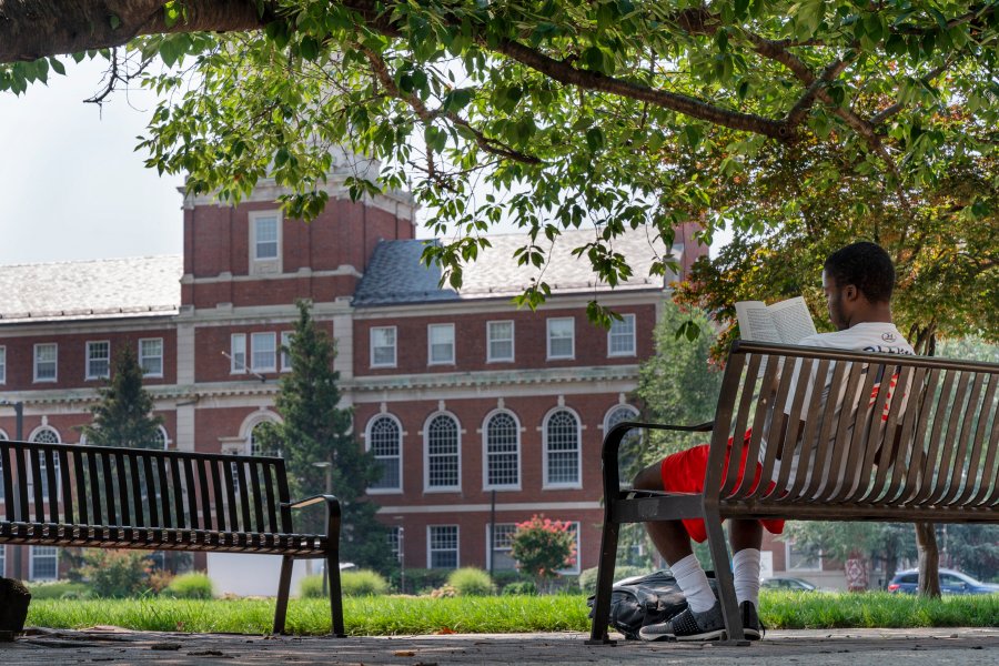 With the Founders Library in the background, a young man reads on Howard University campus July 6, 2021, in Washington. Nationwide, American colleges and universities saw a 4% annual increase in international students this fall, according to survey results released Monday, Nov. 15, by the Institute of International Education. But that follows a decrease of 15% last year, the steepest decline since the institute began publishing data in 1948. (AP Photo/Jacquelyn Martin, File)