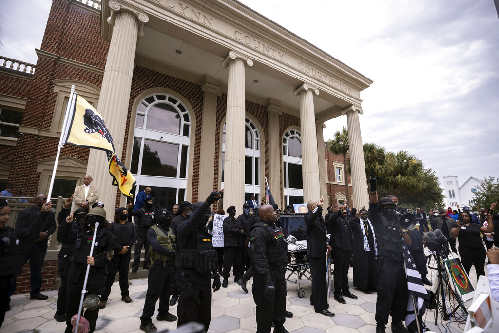 Dozens of Black Lives Matter and Black Panther protesters gather outside the Glynn County Courthouse where the trial of Travis McMichael, his father, Gregory McMichael, and William "Roddie" Bryan is held, Monday, Nov. 22, 2021, in Brunswick, Ga. (AP Photo/Stephen B. Morton)