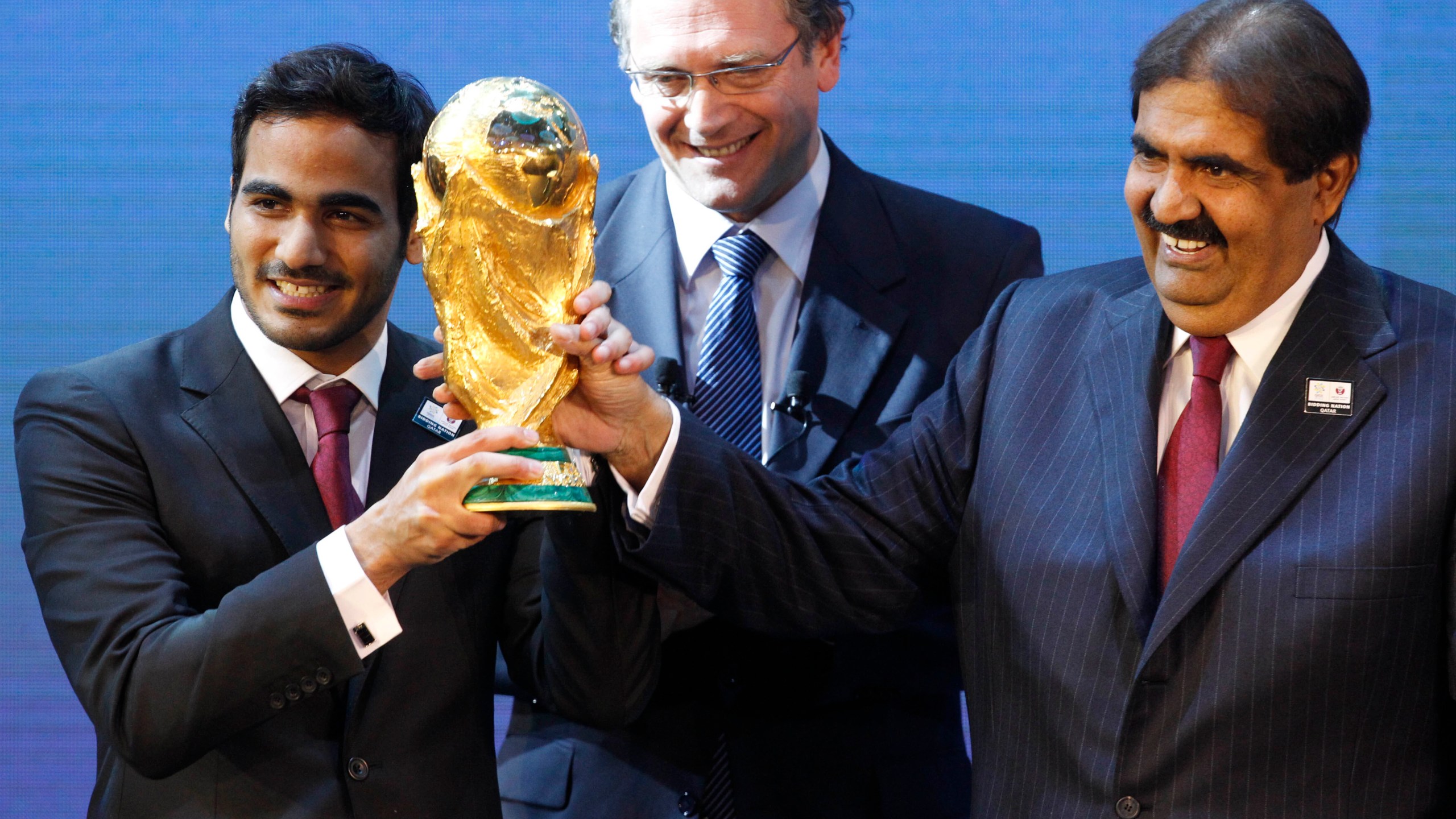 Mohamed bin Hamad Al-Thani, left, Chairman of the 2022 bid committee, and Sheikh Hamad bin Khalifa Al-Thani, Emir of Qatar, hold the World Cup trophy in front of FIFA Secretary General Jerome Valcke after the announcement that Qatar will host the 2022 soccer World Cup, on Dec. 2, 2010, in Zurich, Switzerland. (AP Photo/Anja Niedringhaus, File)