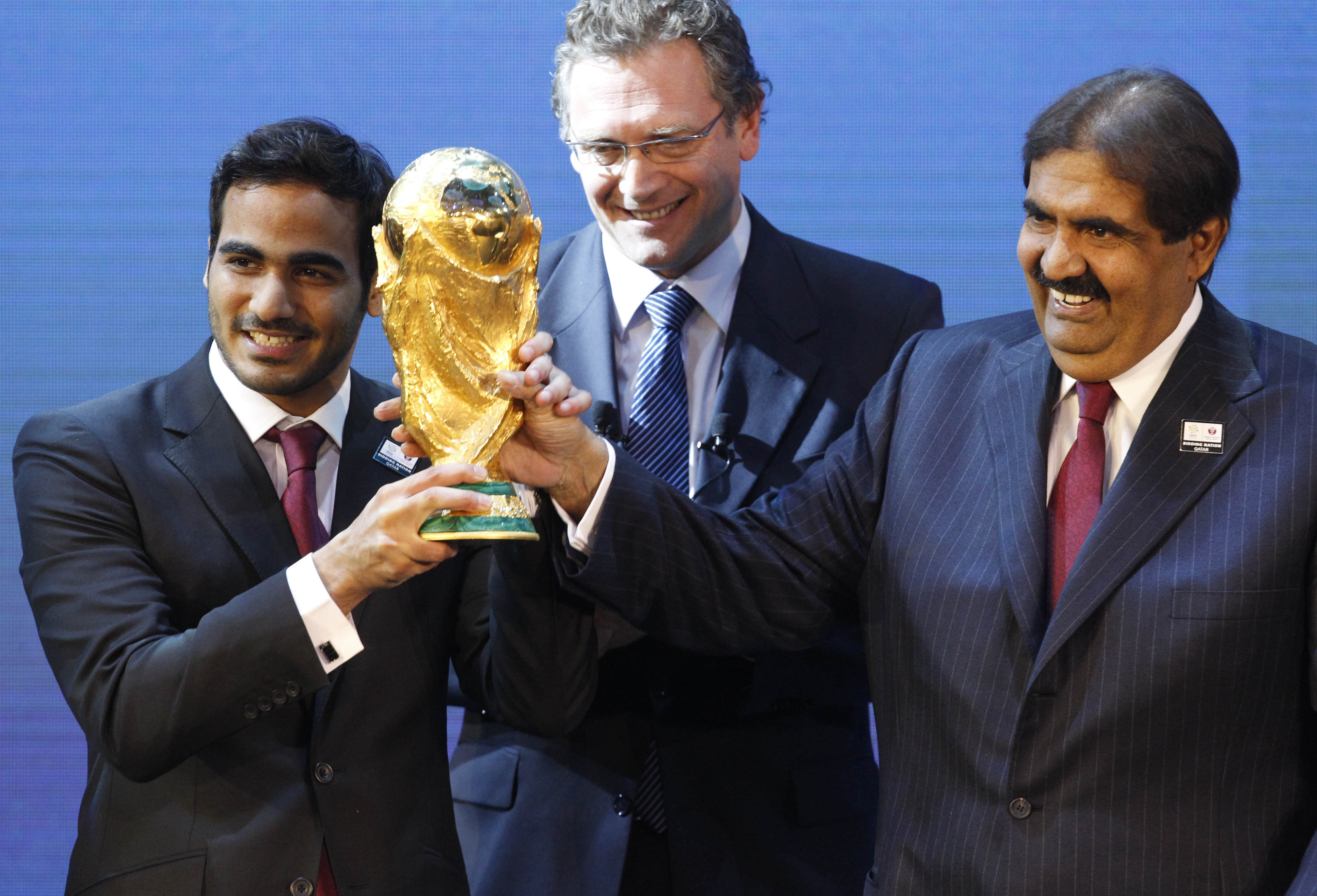 Mohamed bin Hamad Al-Thani, left, Chairman of the 2022 bid committee, and Sheikh Hamad bin Khalifa Al-Thani, Emir of Qatar, hold the World Cup trophy in front of FIFA Secretary General Jerome Valcke after the announcement that Qatar will host the 2022 soccer World Cup, on Dec. 2, 2010, in Zurich, Switzerland. (AP Photo/Anja Niedringhaus, File)