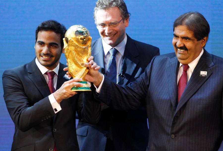 Mohamed bin Hamad Al-Thani, left, Chairman of the 2022 bid committee, and Sheikh Hamad bin Khalifa Al-Thani, Emir of Qatar, hold the World Cup trophy in front of FIFA Secretary General Jerome Valcke after the announcement that Qatar will host the 2022 soccer World Cup, on Dec. 2, 2010, in Zurich, Switzerland. (AP Photo/Anja Niedringhaus, File)