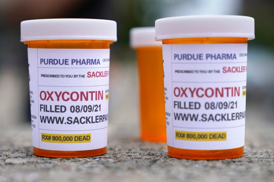 In this Aug. 9, 2021, file photo, fake pill bottles with messages about OxyContin maker Purdue Pharma are displayed during a protest outside the courthouse where the bankruptcy of the company is taking place in White Plains, N.Y. (Seth Wenig/Associated Press)