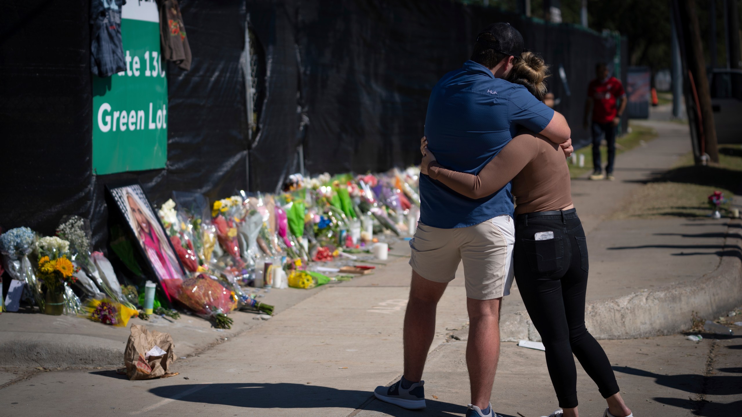 Two people who knew an unidentified victim of a fatal incident at the Houston Astroworld concert embrace at a memorial on Sunday, Nov. 7, 2021. (AP Photo/Robert Bumsted)