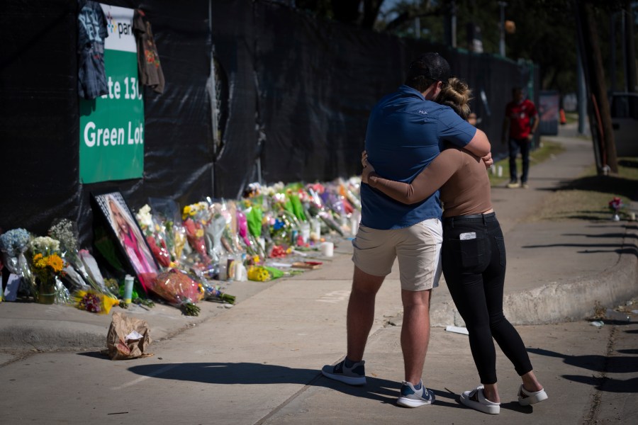 Two people who knew an unidentified victim of a fatal incident at the Houston Astroworld concert embrace at a memorial on Sunday, Nov. 7, 2021. (AP Photo/Robert Bumsted)