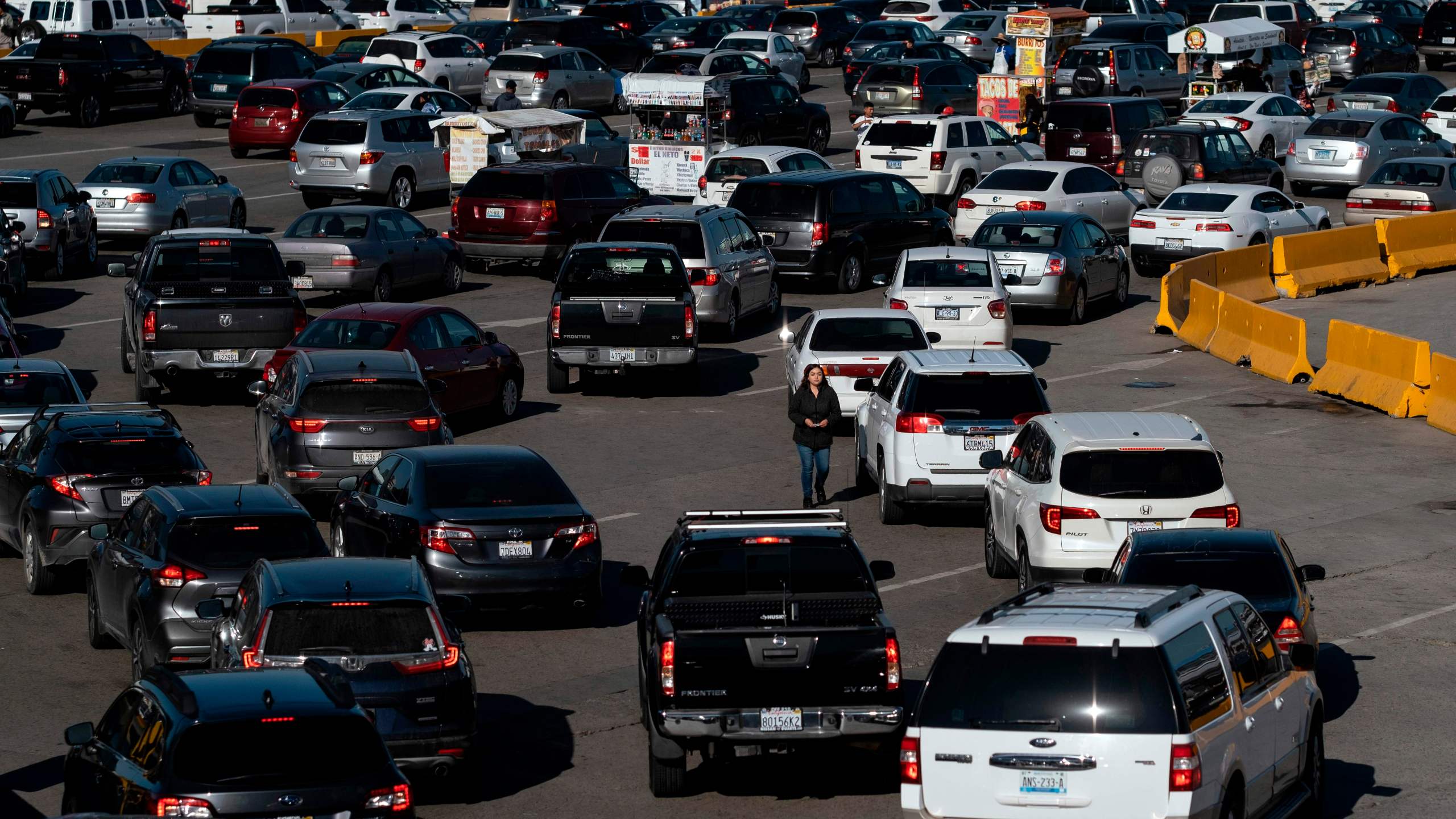 This Feb. 13, 2020 file photo shows cars lining up to cross the U.S.-Mexico border to San Diego at San Ysidro port of entry, in Tijuana, Baja California state, Mexico. (GUILLERMO ARIAS/AFP via Getty Images)