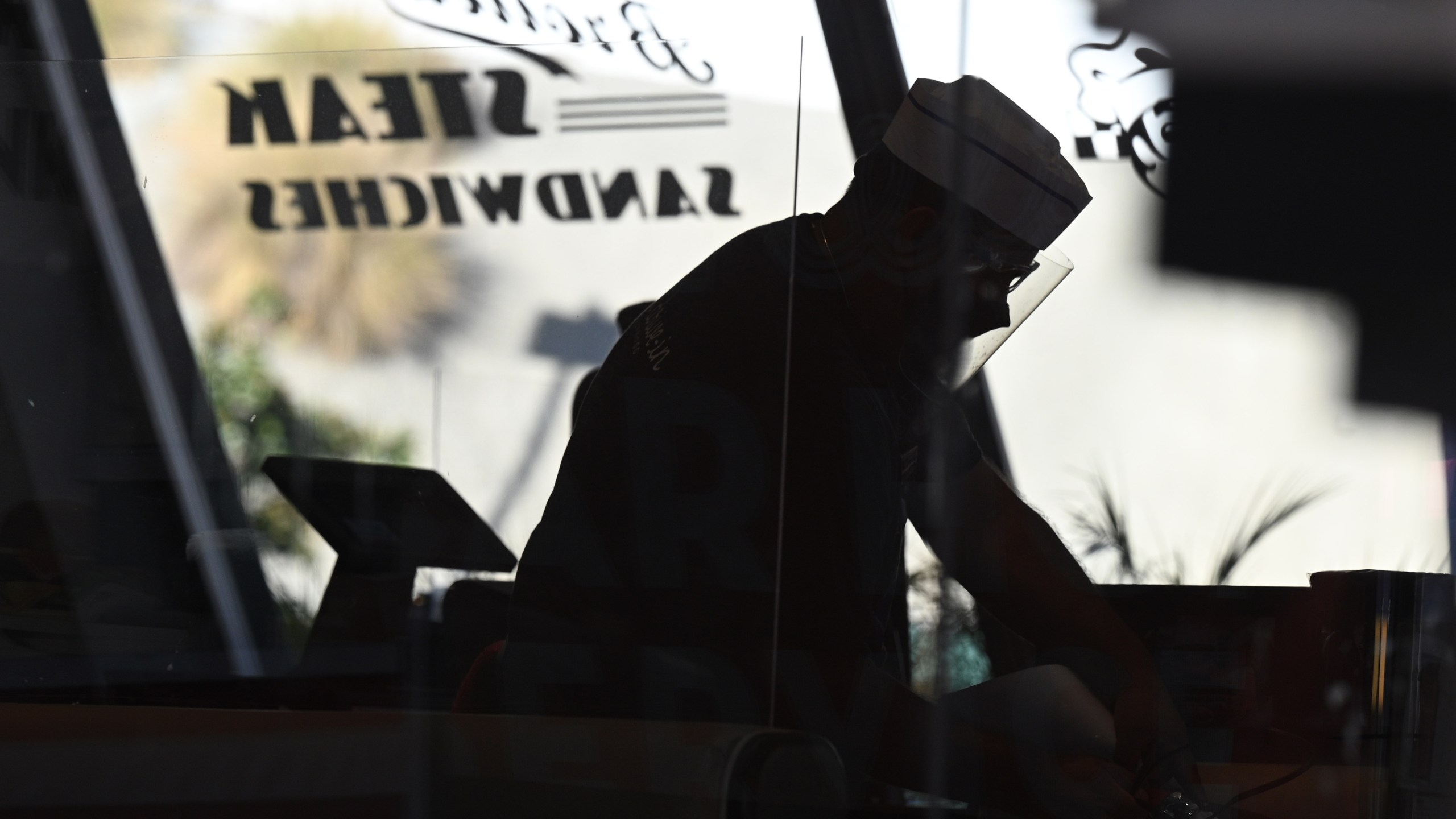 Restaurant servers clean tables inside Mel's drive-in diner in West Hollywood on Nov. 30, 2020. (ROBYN BECK/AFP via Getty Images)