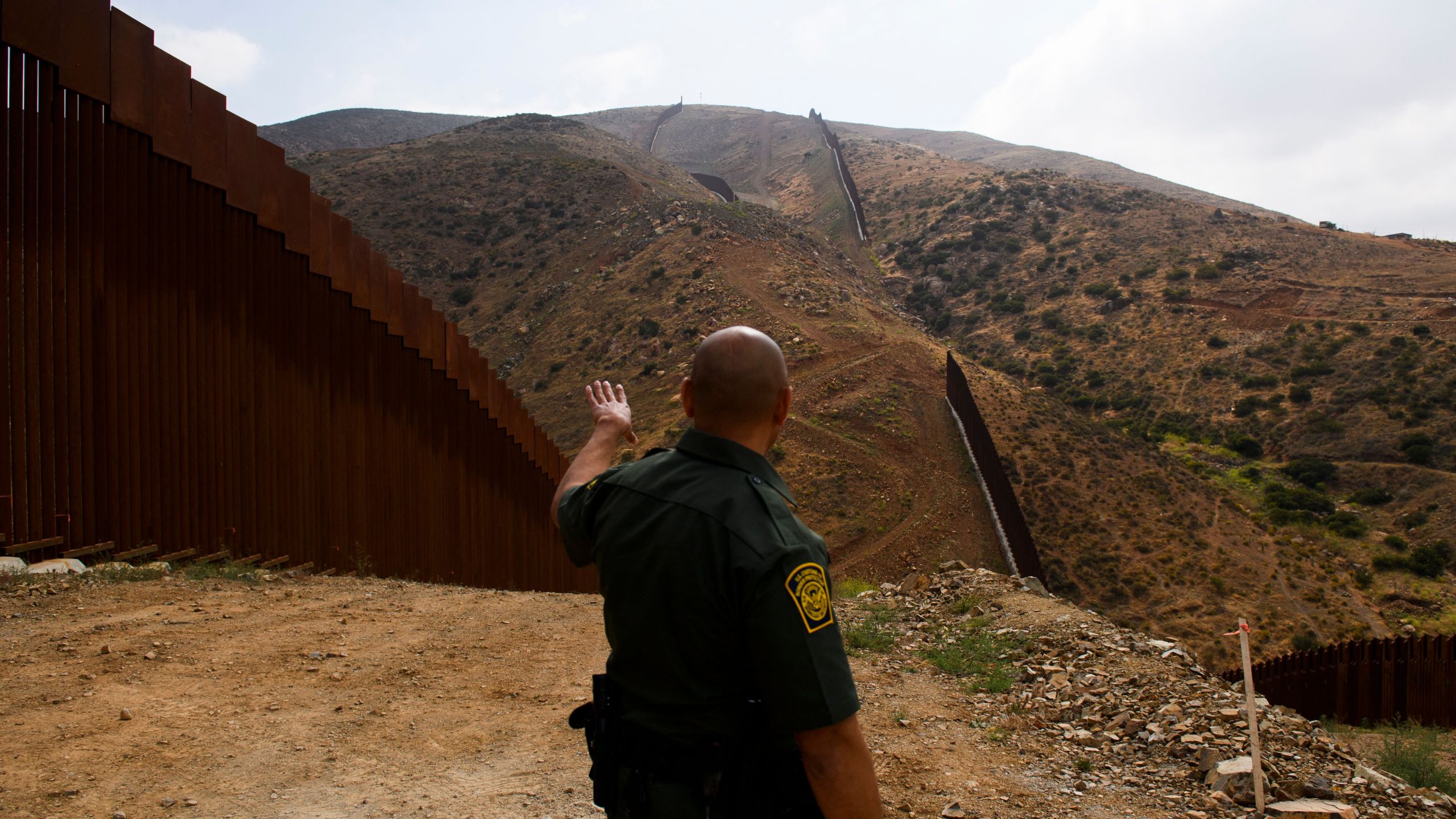 A U.S. Border Patrol agent shows an incomplete section of a border wall on a hillside along the U.S.-Mexico border between San Diego and Tijuana on May 10, 2021 in the Otay Mesa area. (PATRICK T. FALLON/AFP via Getty Images)