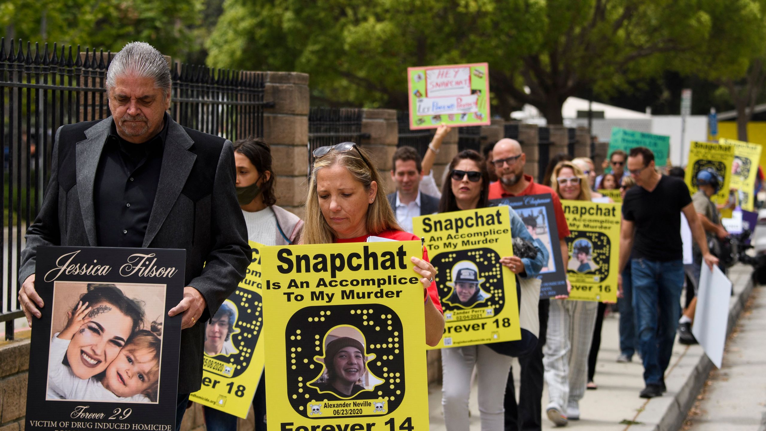 Steve Filson (L), whose daughter Jessica Filson died in January 2020 of fentanyl poisoning, and Amy Neville (R), whose son Alexander Neville died in June 2020 at the age of 14 of fentanyl poisoning, march with family and friends to protest outside of the Snap, Inc. headquarters, makers of the Snapchat social media application, on June 4, 2021 in Santa Monica.(PATRICK T. FALLON/AFP via Getty Images)