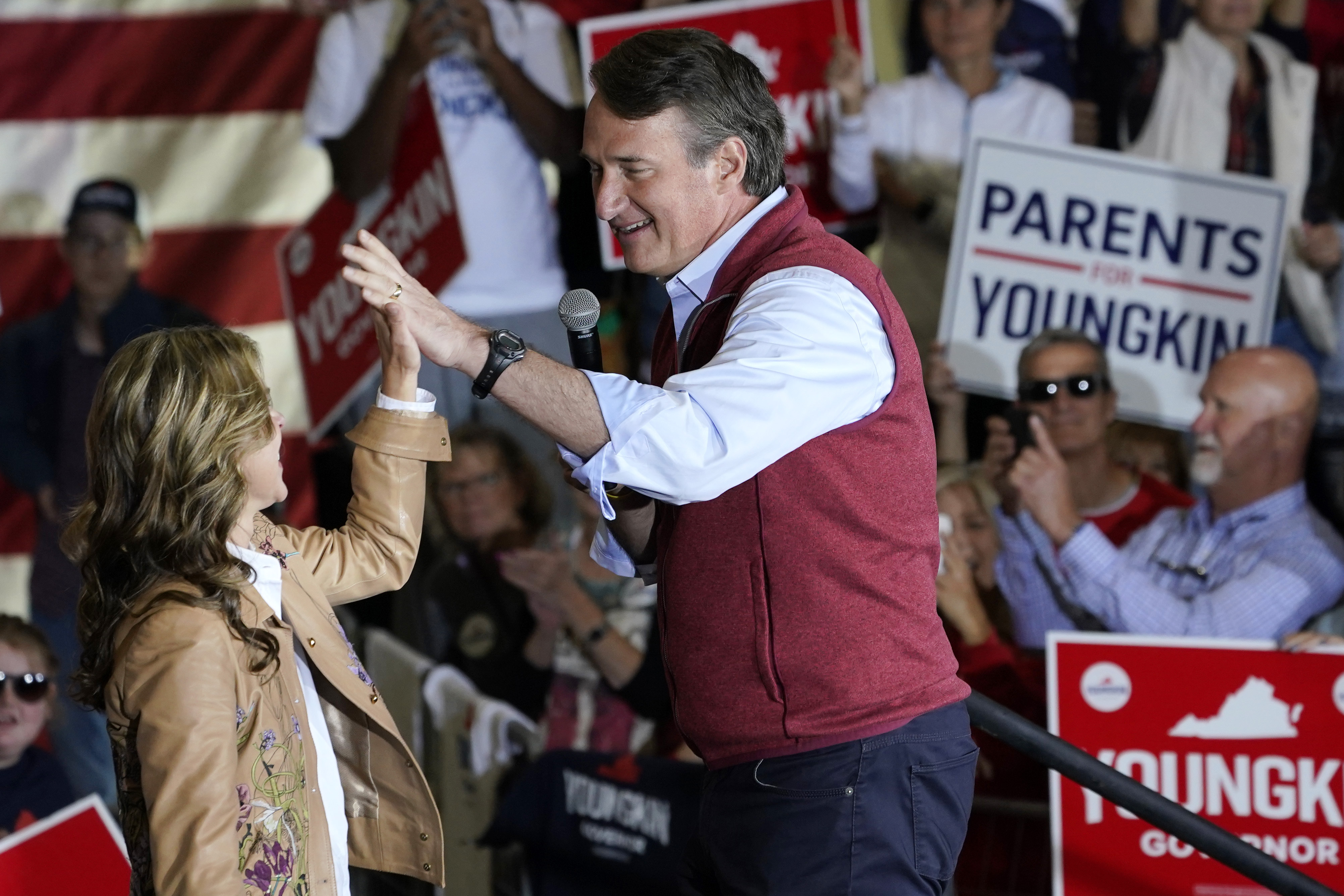 Republican gubernatorial candidate Glenn Youngkin, right, gives his wife Suzanne, a high five during a rally in Chesterfield, Va., Monday, Nov. 1, 2021. Youngkin will face Democrat former Gov. Terry McAuliffe in the November election. (AP Photo/Steve Helber)