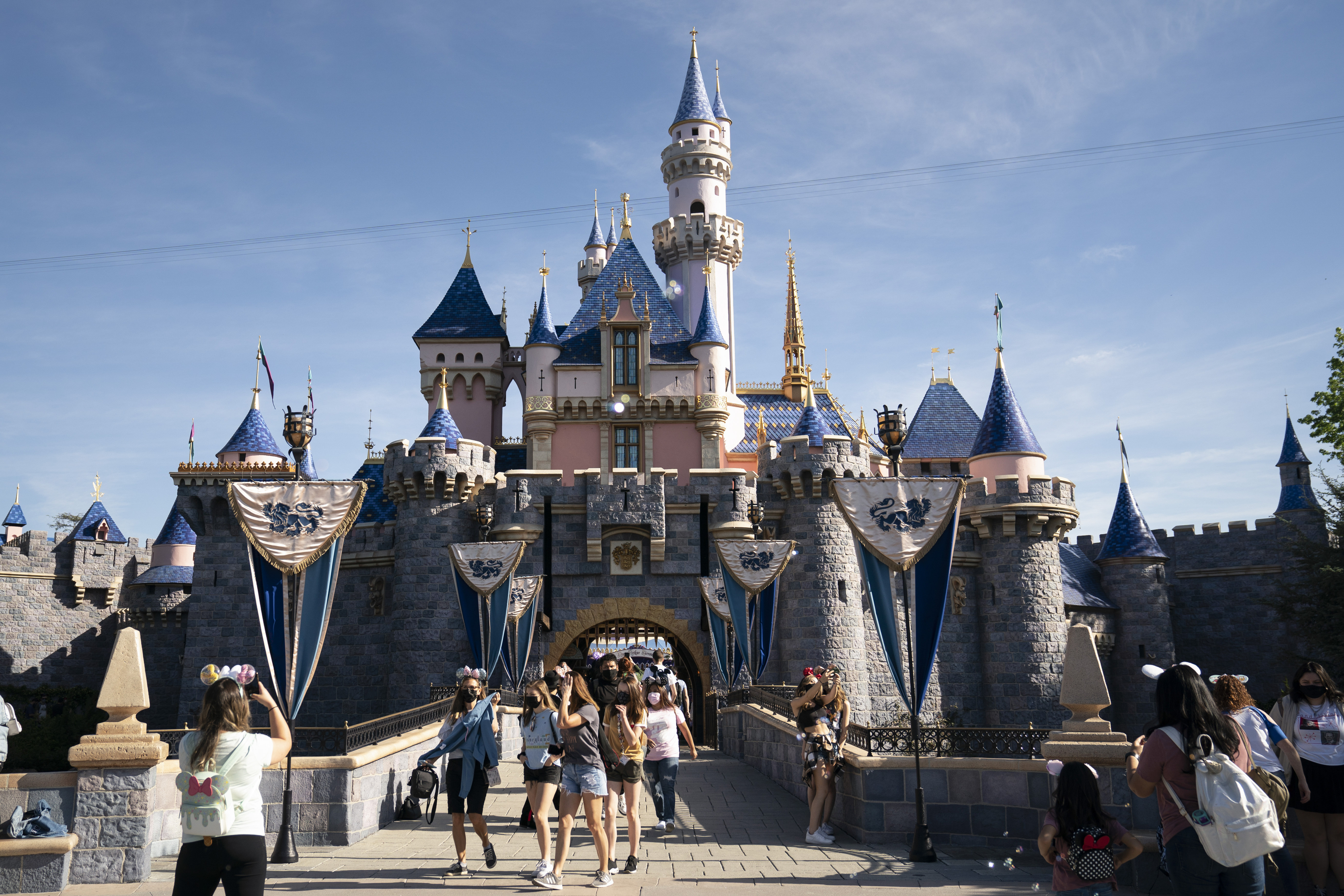 In this Friday, April 30, 2021, file photo, visitors exit The Sleeping Beauty Castle at Disneyland in Anaheim, Calif. (AP Photo/Jae C. Hong, File)