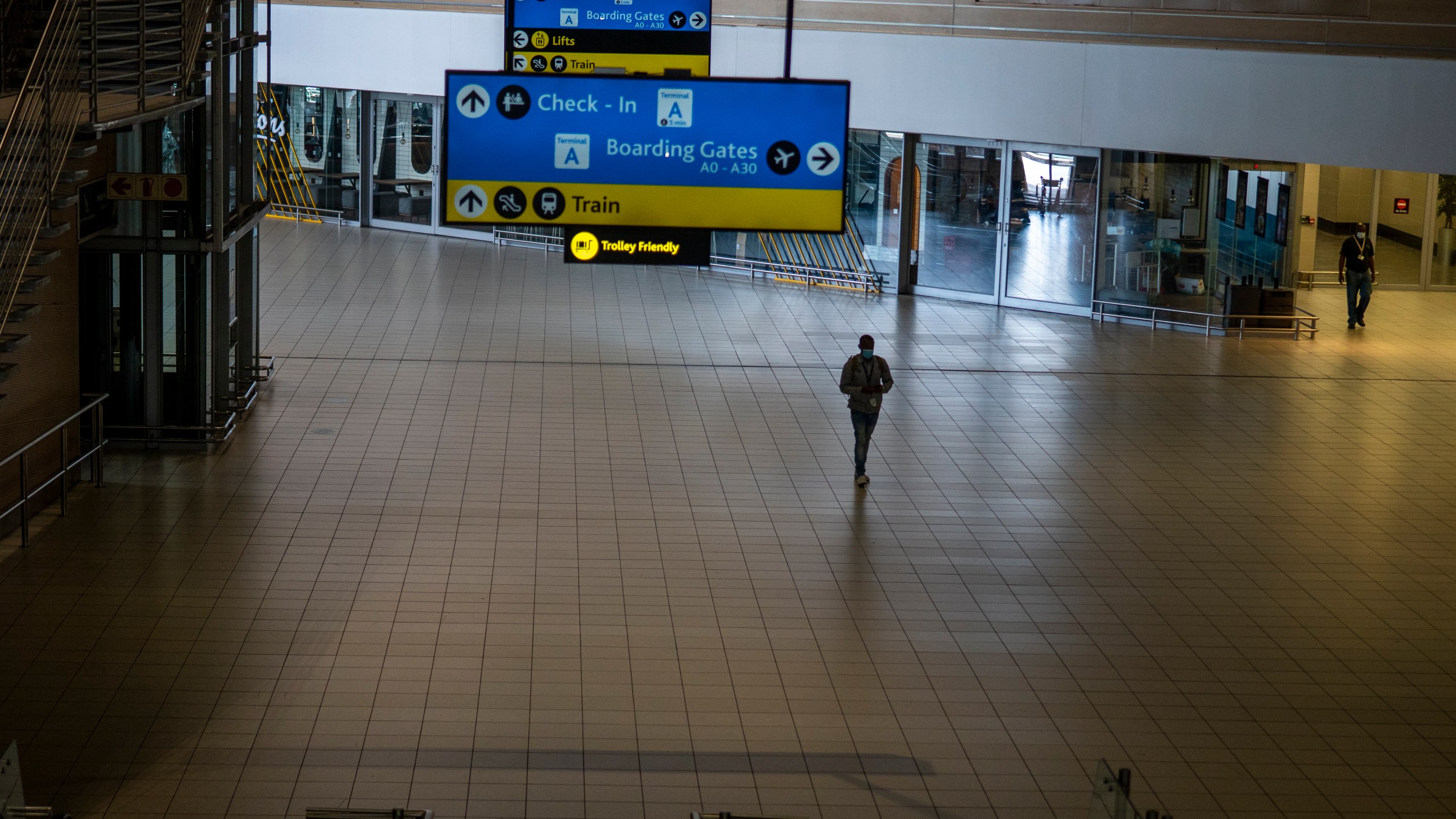 A man walks through a deserted part of Johannesburg's OR Tambo's airport, South Africa, Monday Nov. 29, 2021. As countries shut their doors to foreign tourists or reimpose restrictions because of the new omicron variant of the coronavirus, tourism that was just finding it's footing again could face another major pandemic slowdown amid the uncertainty about the new strain. (AP Photo/Jerome Delay, File)