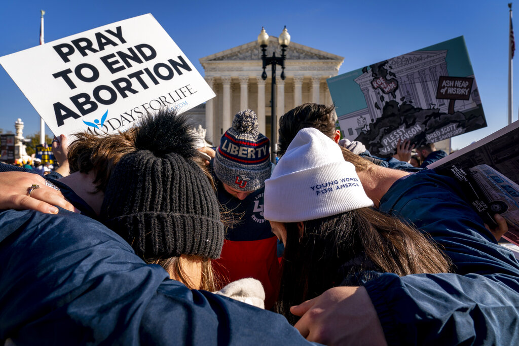 A group of anti-abortion protesters pray together in front of the U.S. Supreme Court, Dec. 1, 2021, in Washington. (AP Photo/Andrew Harnik, File)