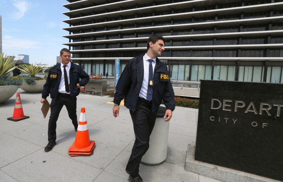 FBI agents leave the headquarters of the Los Angeles Department of Water and Power after spending several hours inside the building on July 22, 2019. David Wright, the former head of the Los Angeles Department of Water and Power, the nation's largest public utility, has agreed to plead guilty to taking bribes in a corruption scandal that grew out of an automated billing disaster that stuck ratepayers with exorbitant bills, federal prosecutors said Monday, Dec. 6, 2021. Los Angeles Mayor Eric Garcetti removed Wright from his job in 2019 after the FBI raided the water and power department and other city offices, months before his expected departure date. (AP Photo/Reed Saxon, File)